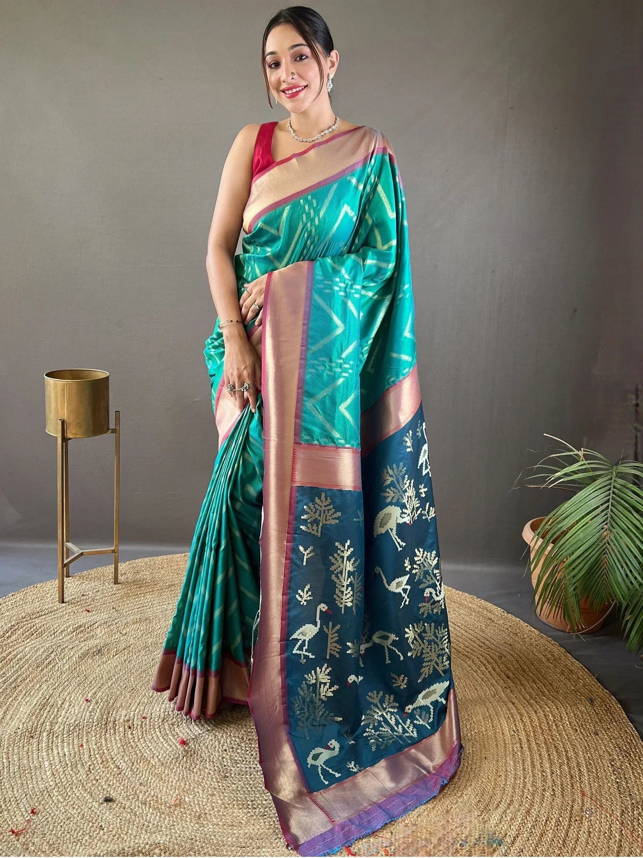 Woman in teal and navy blue ethnic saree with bird and tree motifs, perfect for Indian occasions