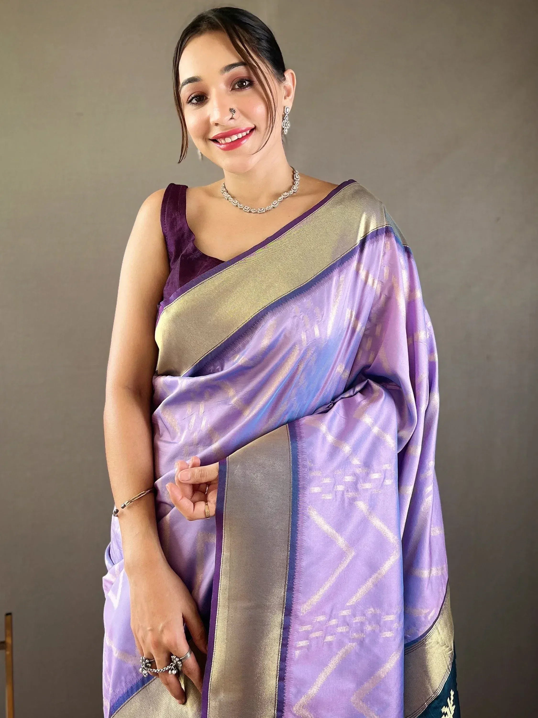 Woman in purple and gold designer saree with geometric weave, ethnic wear for festive occasions