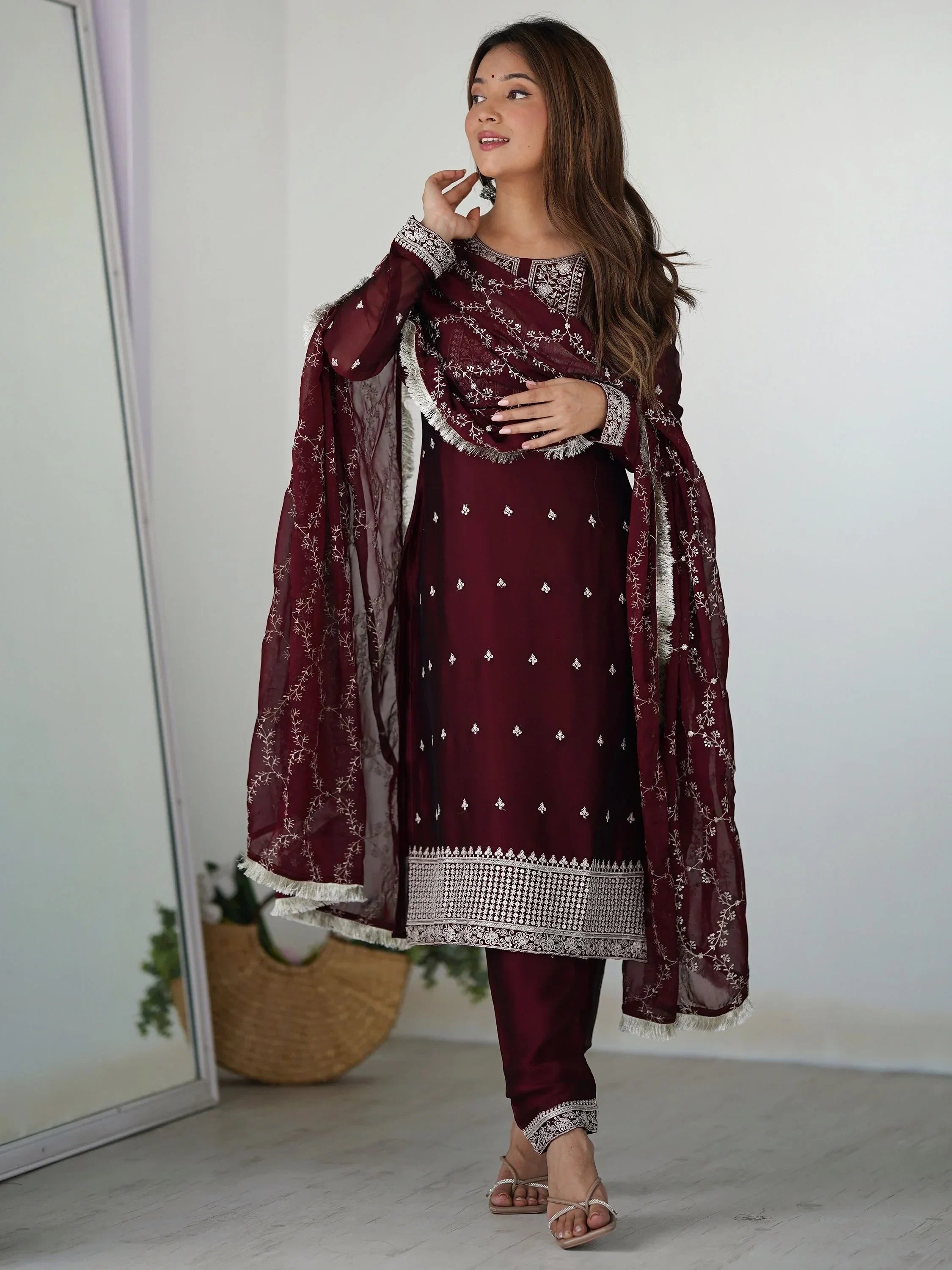 Woman wearing maroon embroidered salwar kameez set with dupatta and sandals