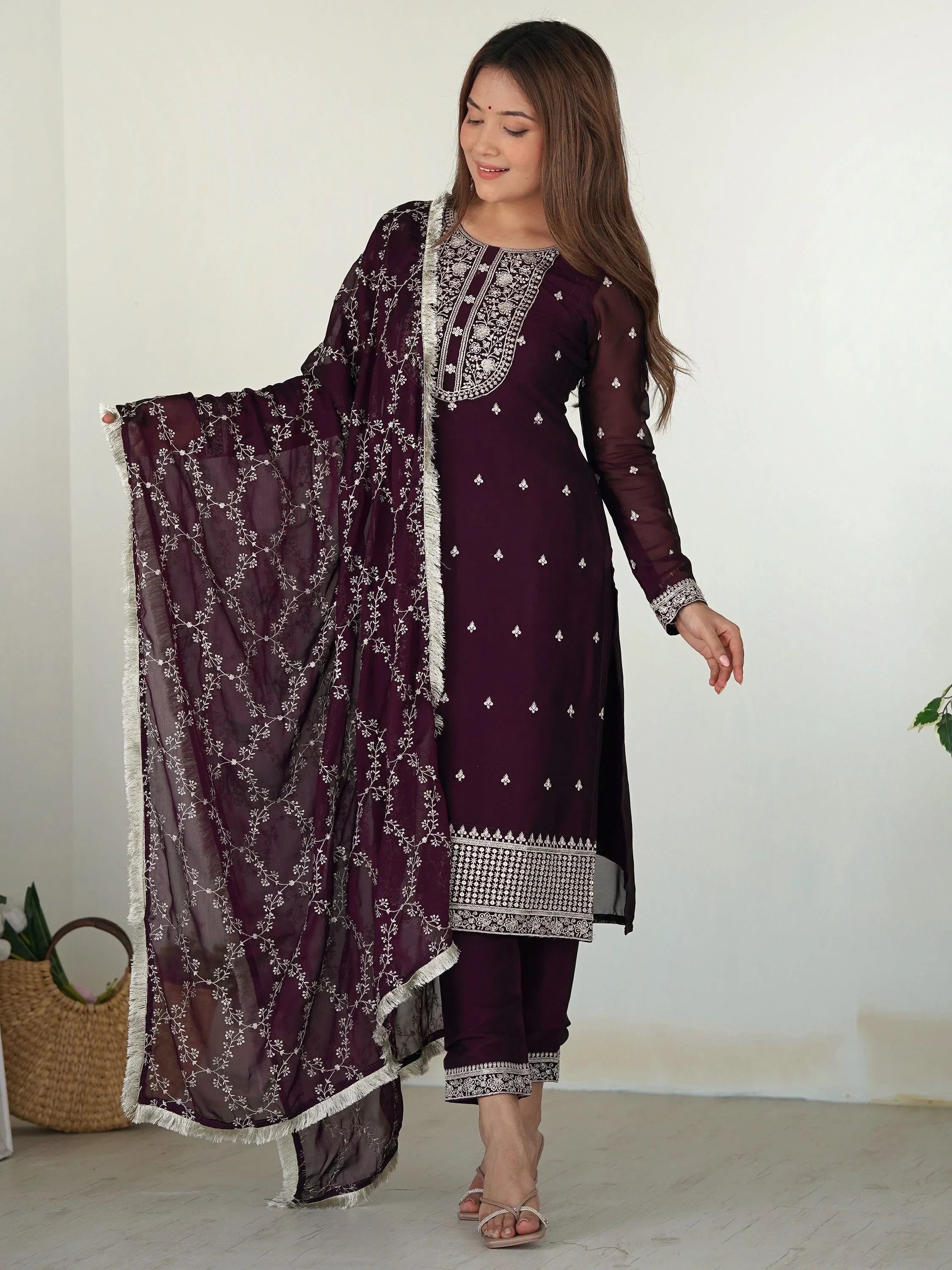 Woman wearing maroon embroidered salwar kameez with matching dupatta