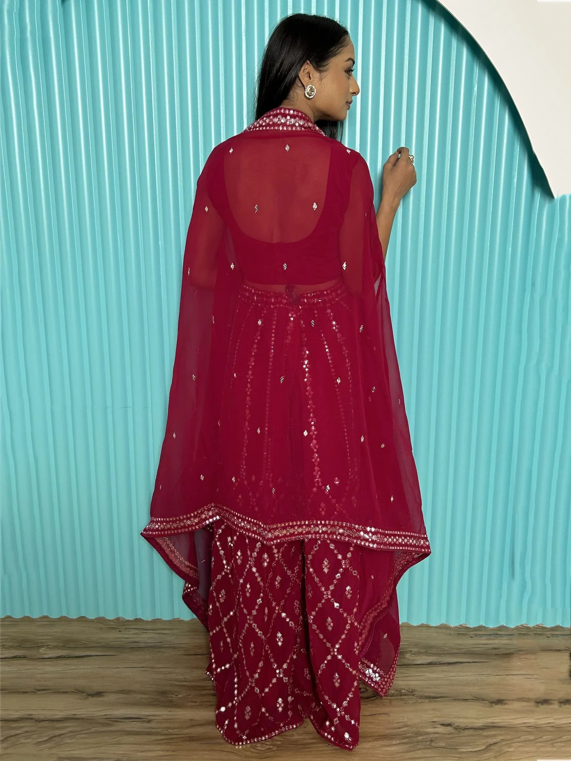 Woman in maroon sequin embroidered lehenga choli with dupatta, facing away