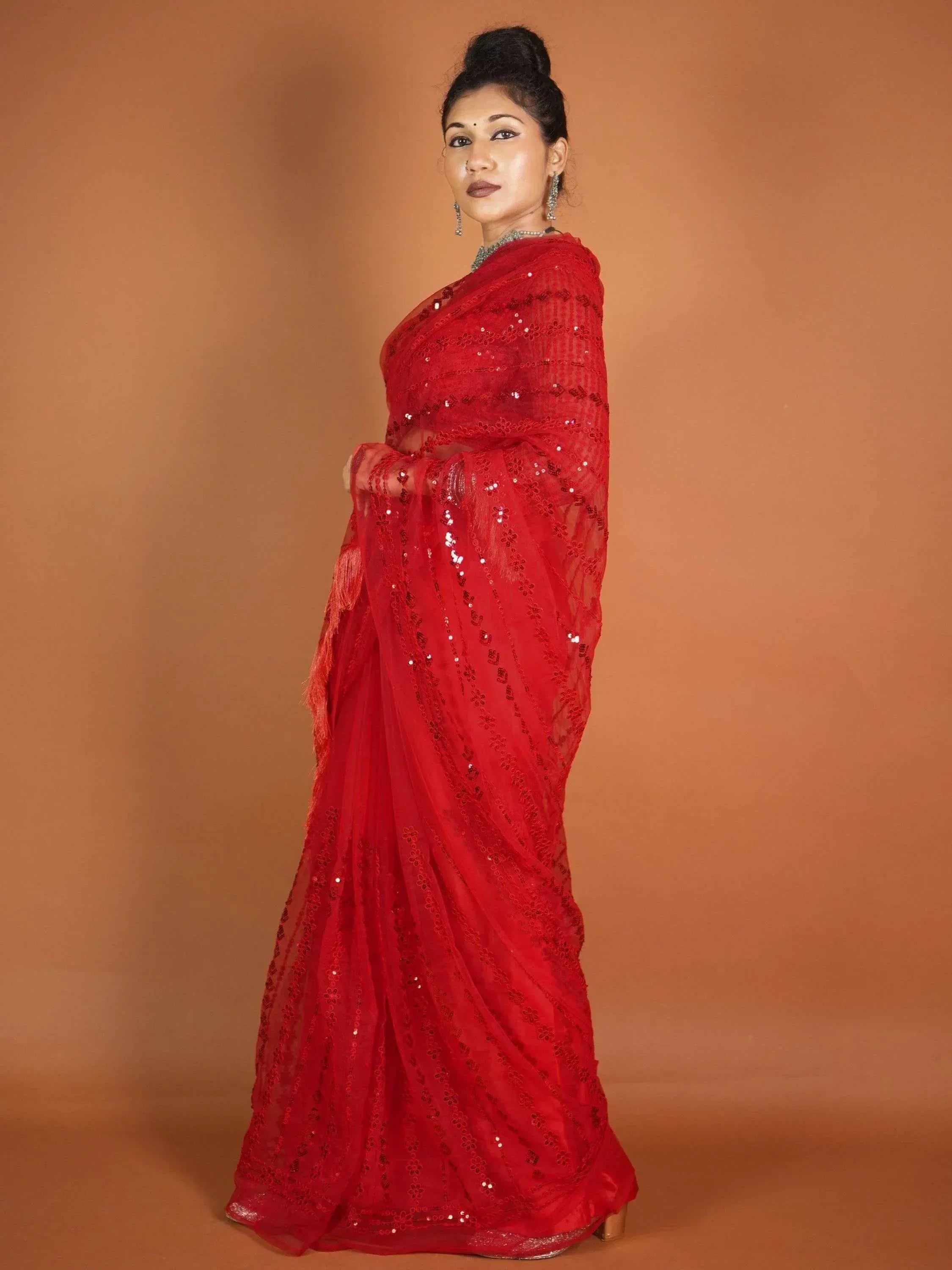 Red sequin-embellished Indian saree with sheer overlay, perfect for festive occasions and ethnic events.