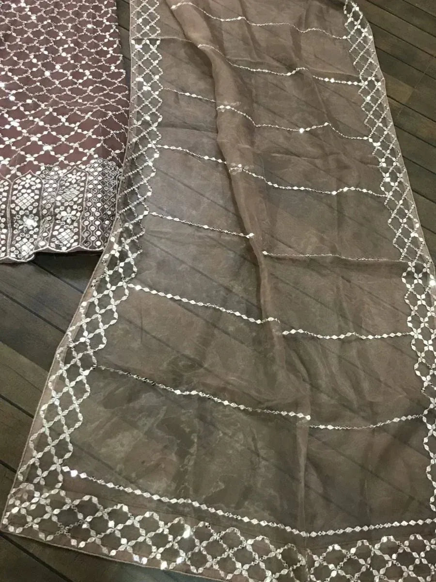 Brown ethnic saree with silver mirror work and geometric border, perfect for Indian occasions