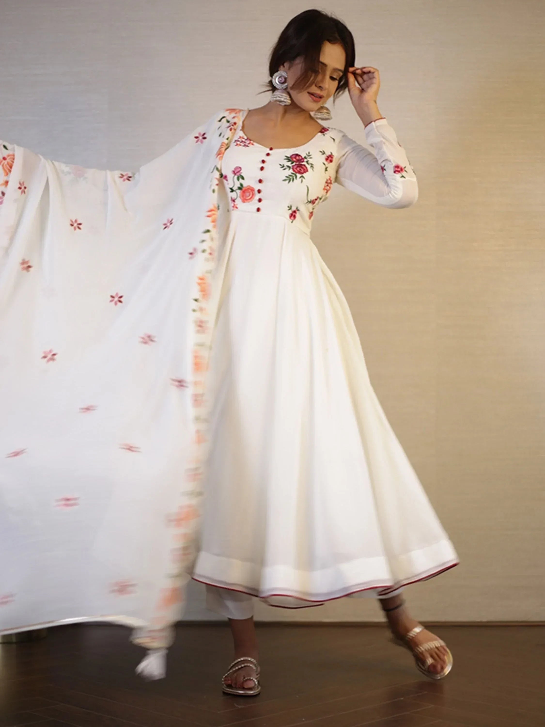 Woman in white floral embroidered Anarkali suit with matching dupatta and ethnic earrings