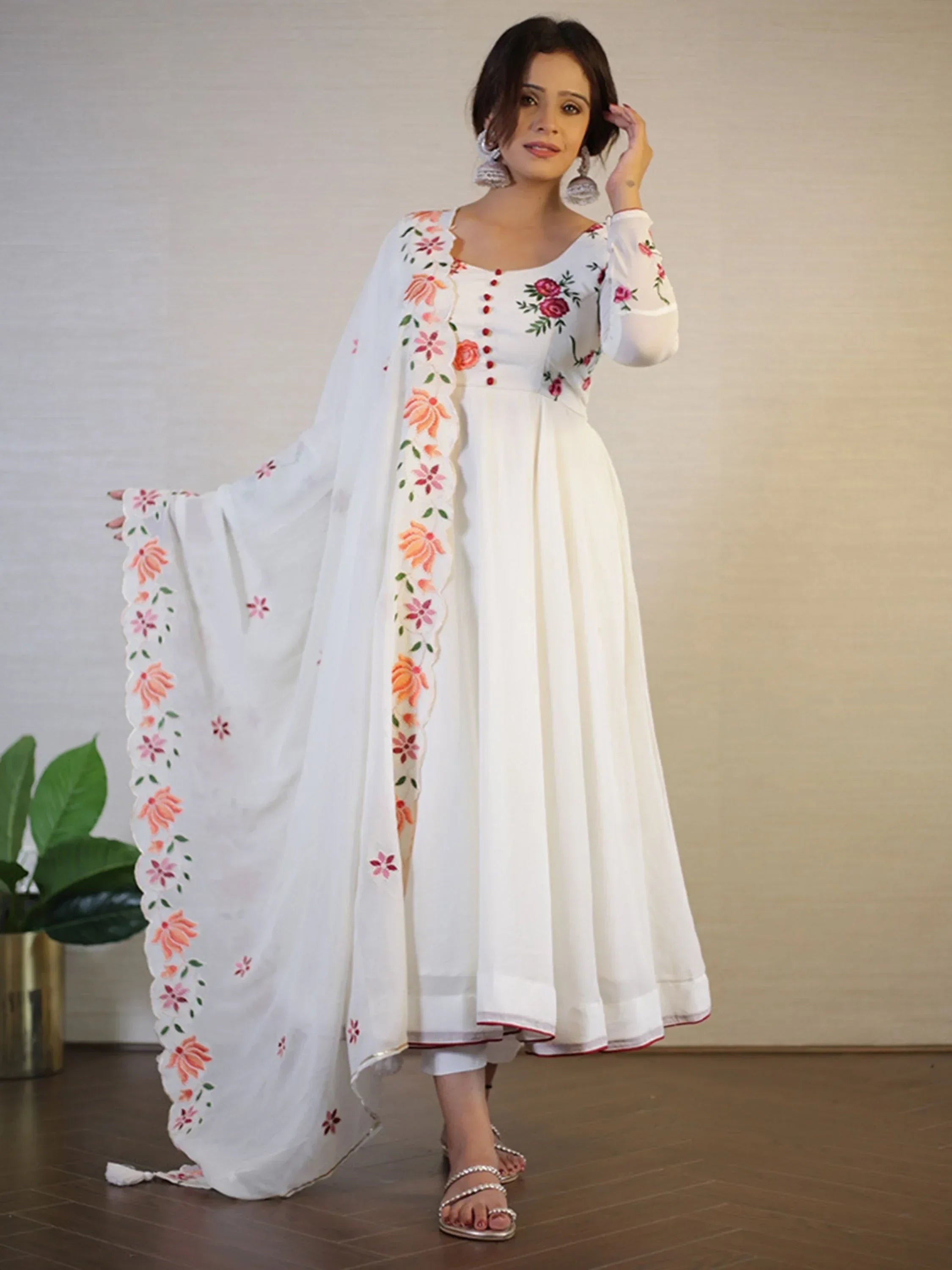 Woman wearing white embroidered Anarkali suit with floral dupatta, ethnic Indian attire