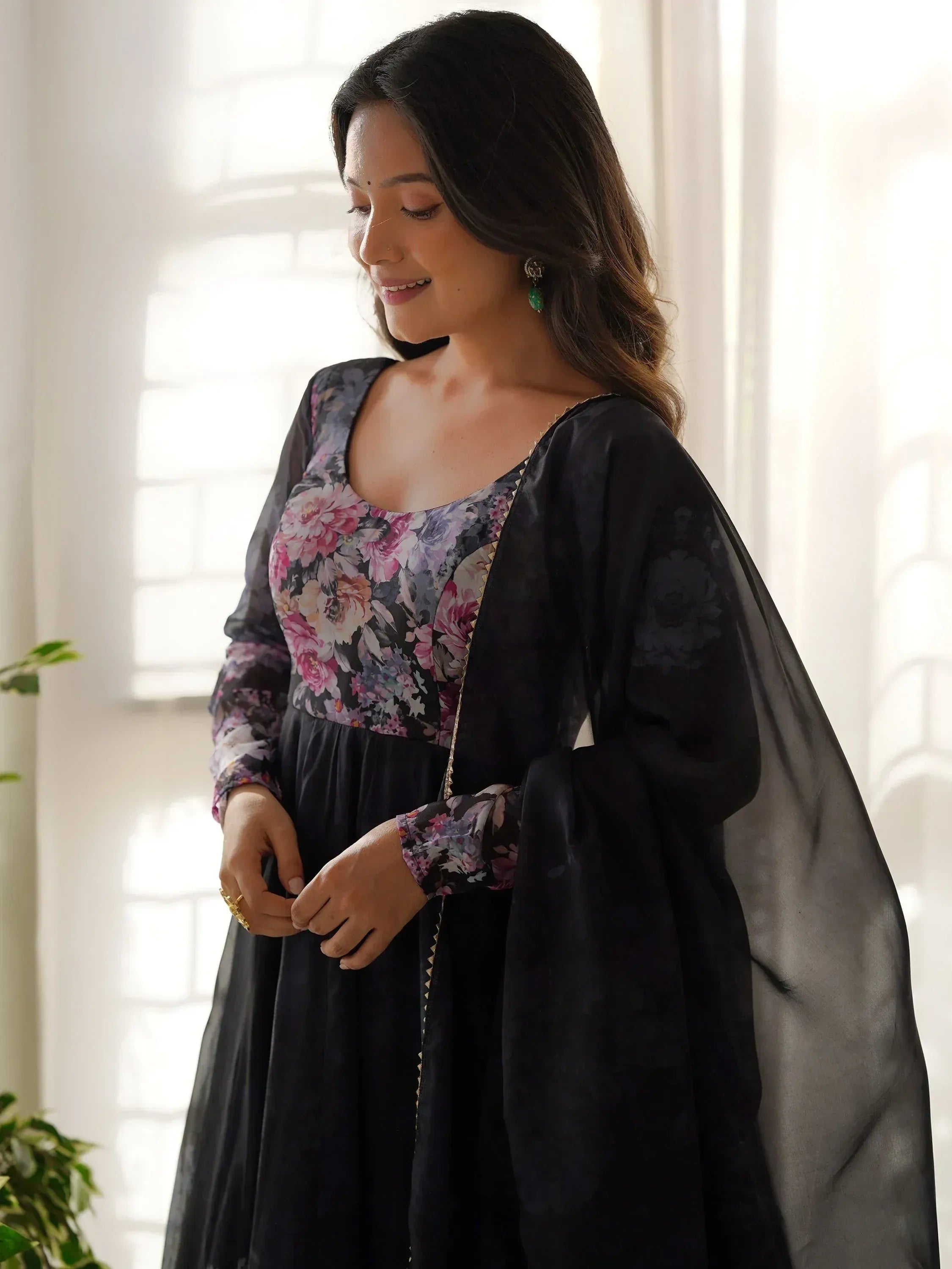 Woman in black floral ethnic gown with sheer cape, perfect for Indian occasions
