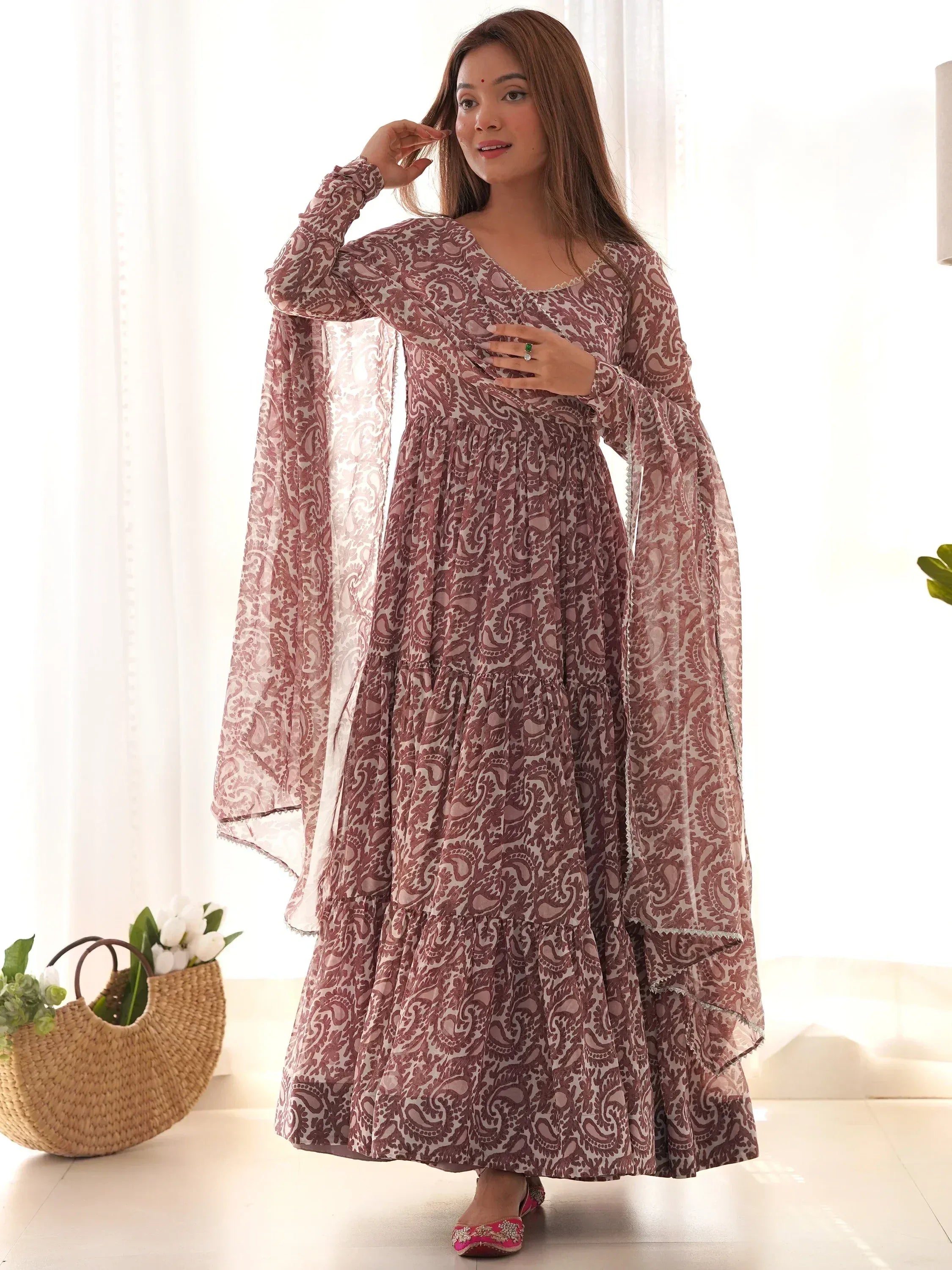 Woman in maroon and white printed ethnic gown with flared sleeves, indoor setting