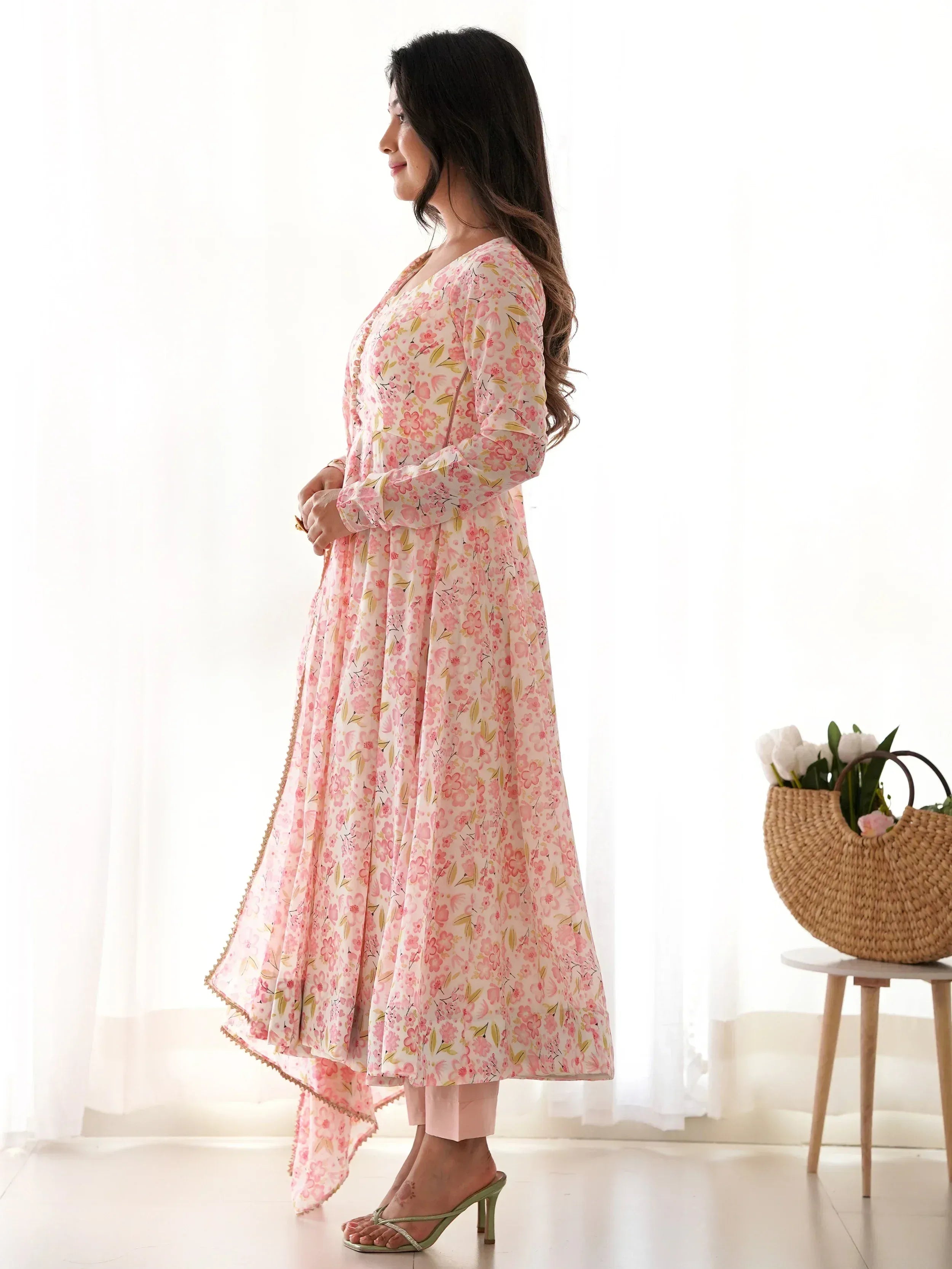 Pink floral printed ethnic gown with asymmetrical hem, paired with palazzo pants and heels