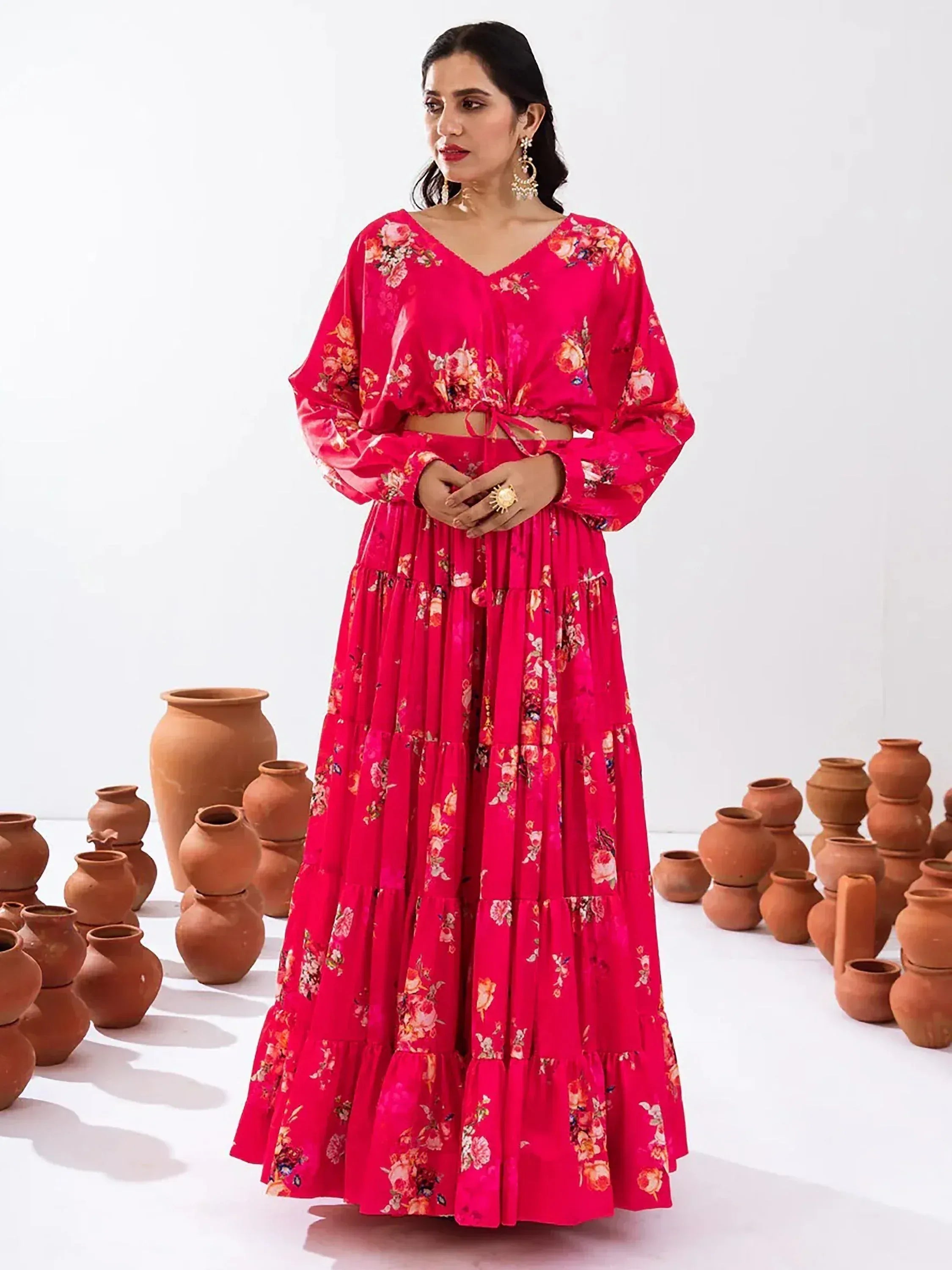 Vibrant pink floral printed ethnic gown with tiered skirt and long sleeves, styled with gold jewelry