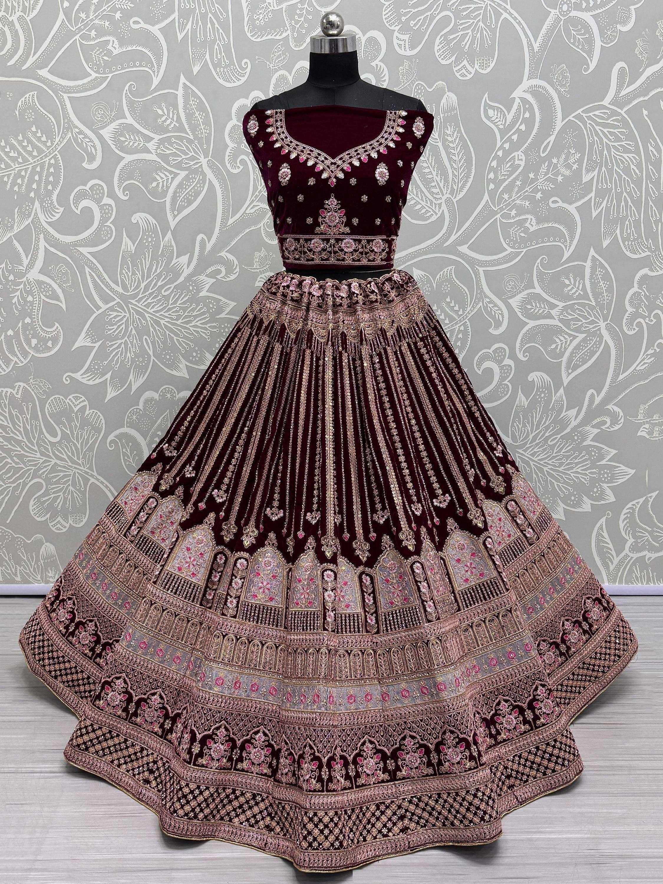 Maroon velvet lehenga choli with intricate gold and pink embroidery, perfect for Indian ethnic wear.