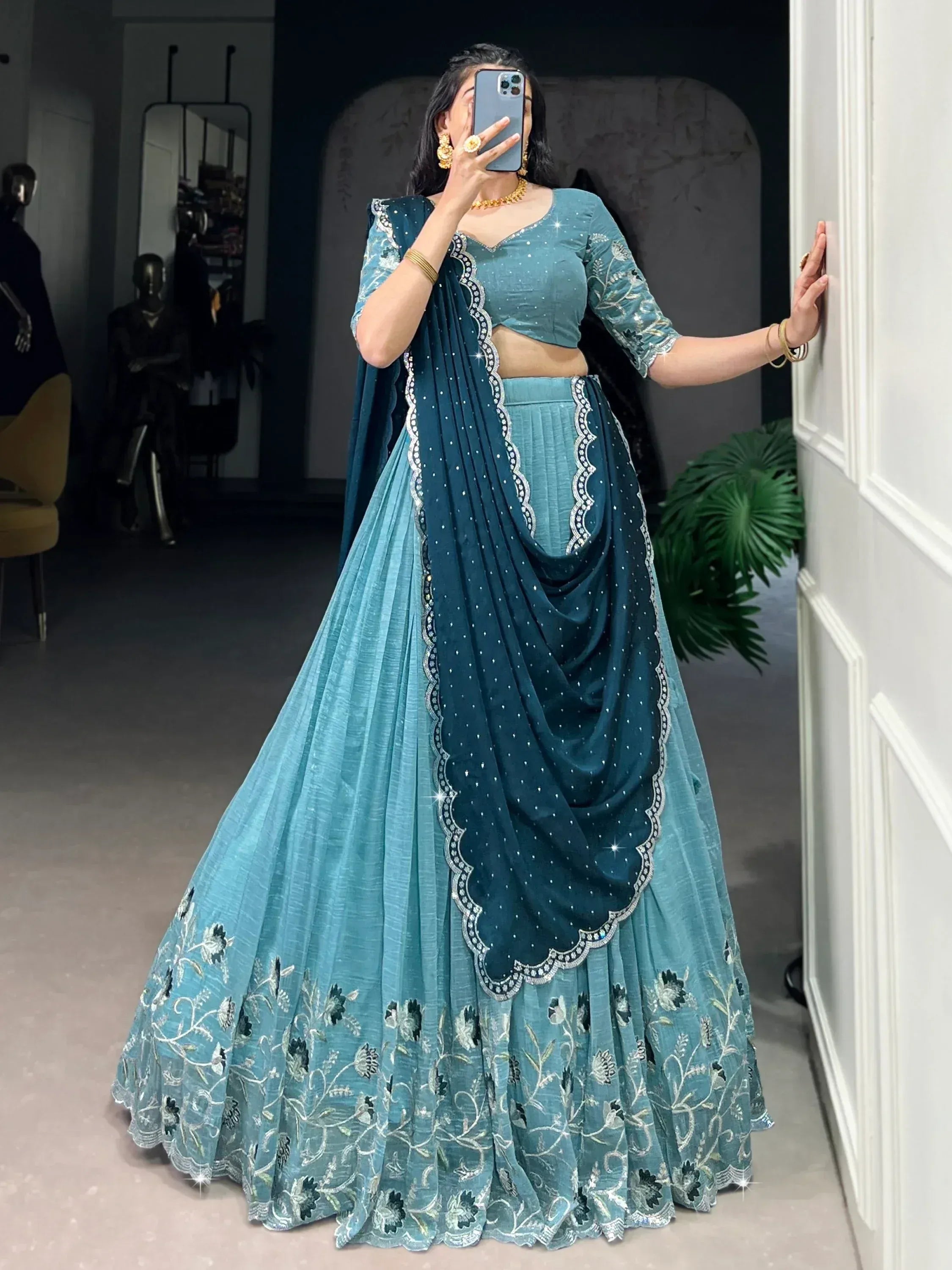 Teal blue designer lehenga choli with floral embroidery and sequin detailing, perfect for Indian ethnic wear occasions.