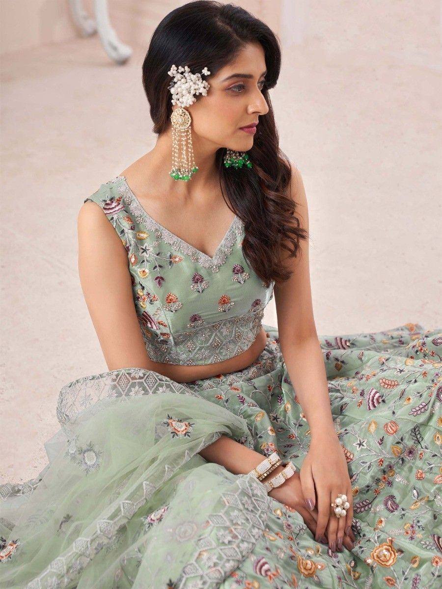 Mint green embroidered lehenga choli with floral motifs and pearl jewelry for Indian ethnic wear