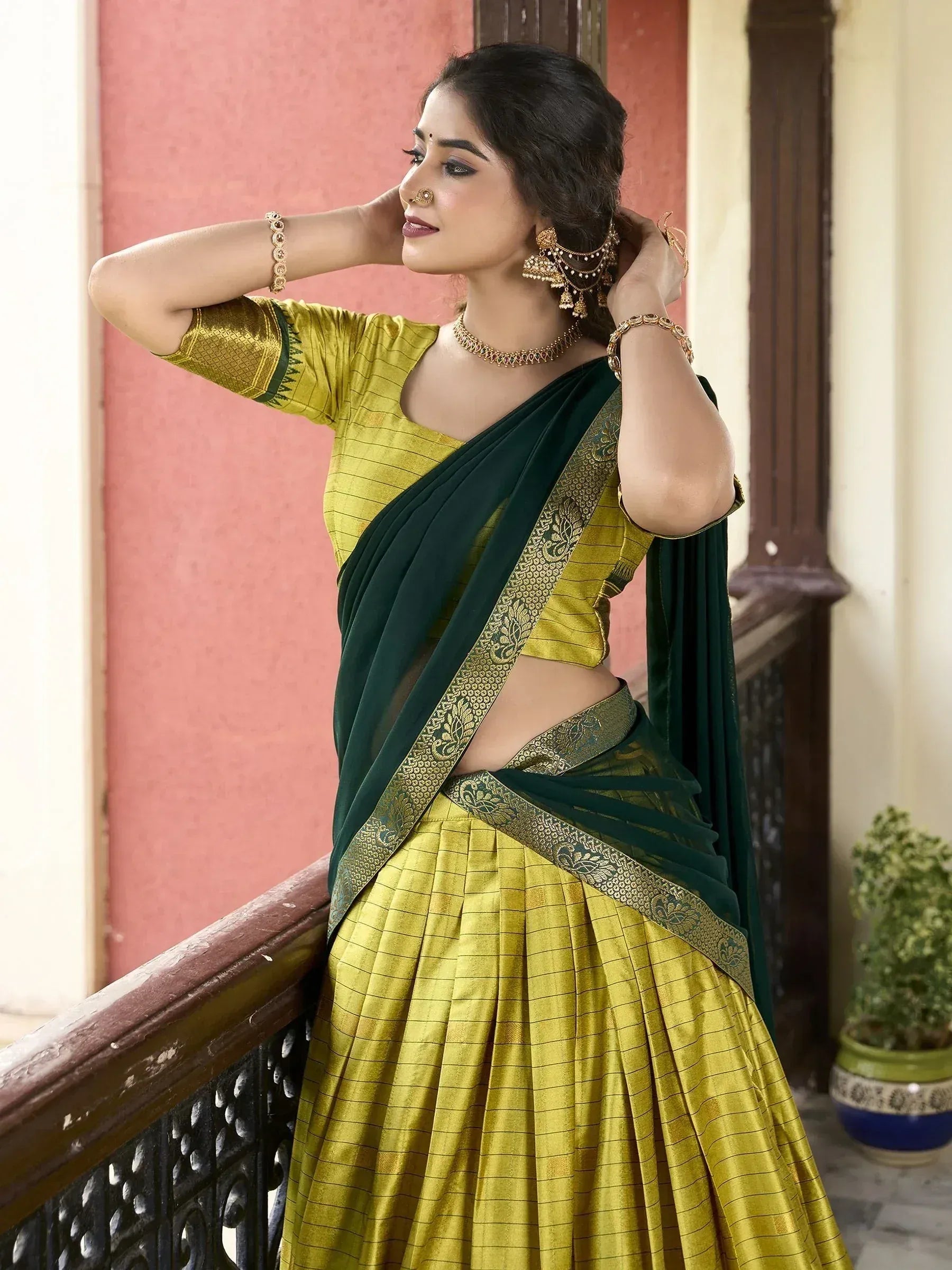 Woman in green and gold designer lehenga choli with embroidered saree drape, ethnic Indian wear