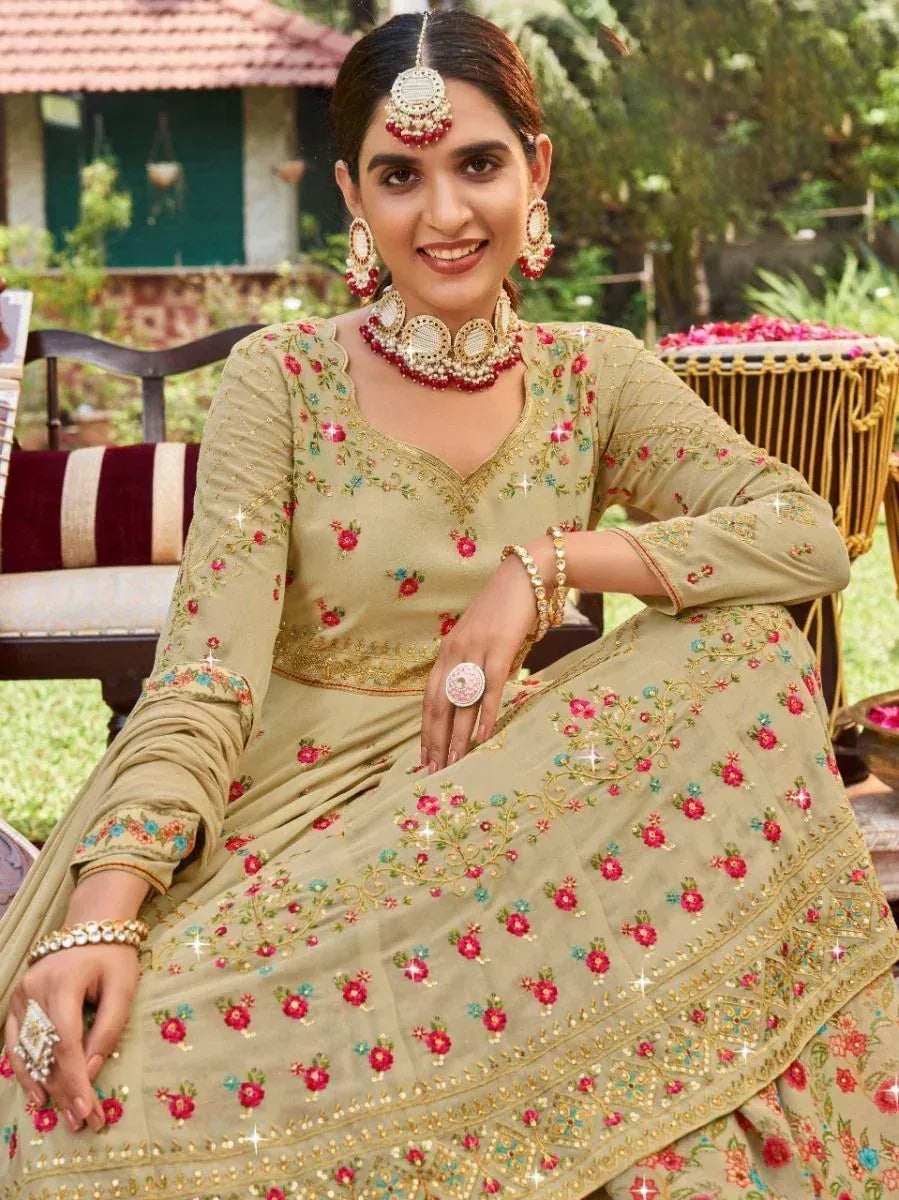 Woman in olive green floral embroidered lehenga choli with traditional jewelry, perfect for Indian ethnic occasions.