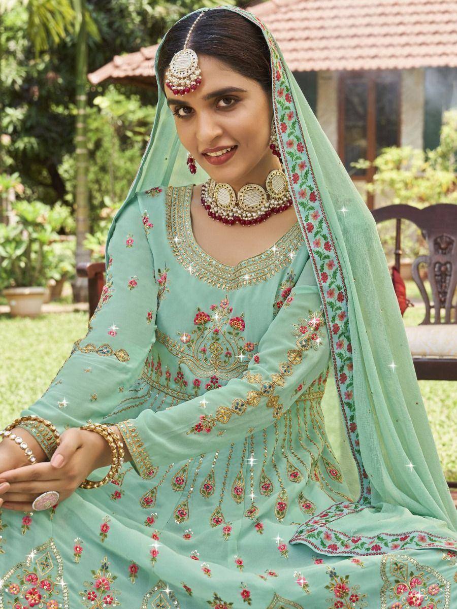 Mint green embroidered salwar kameez with floral motifs, dupatta, and traditional Indian jewelry for festive occasions