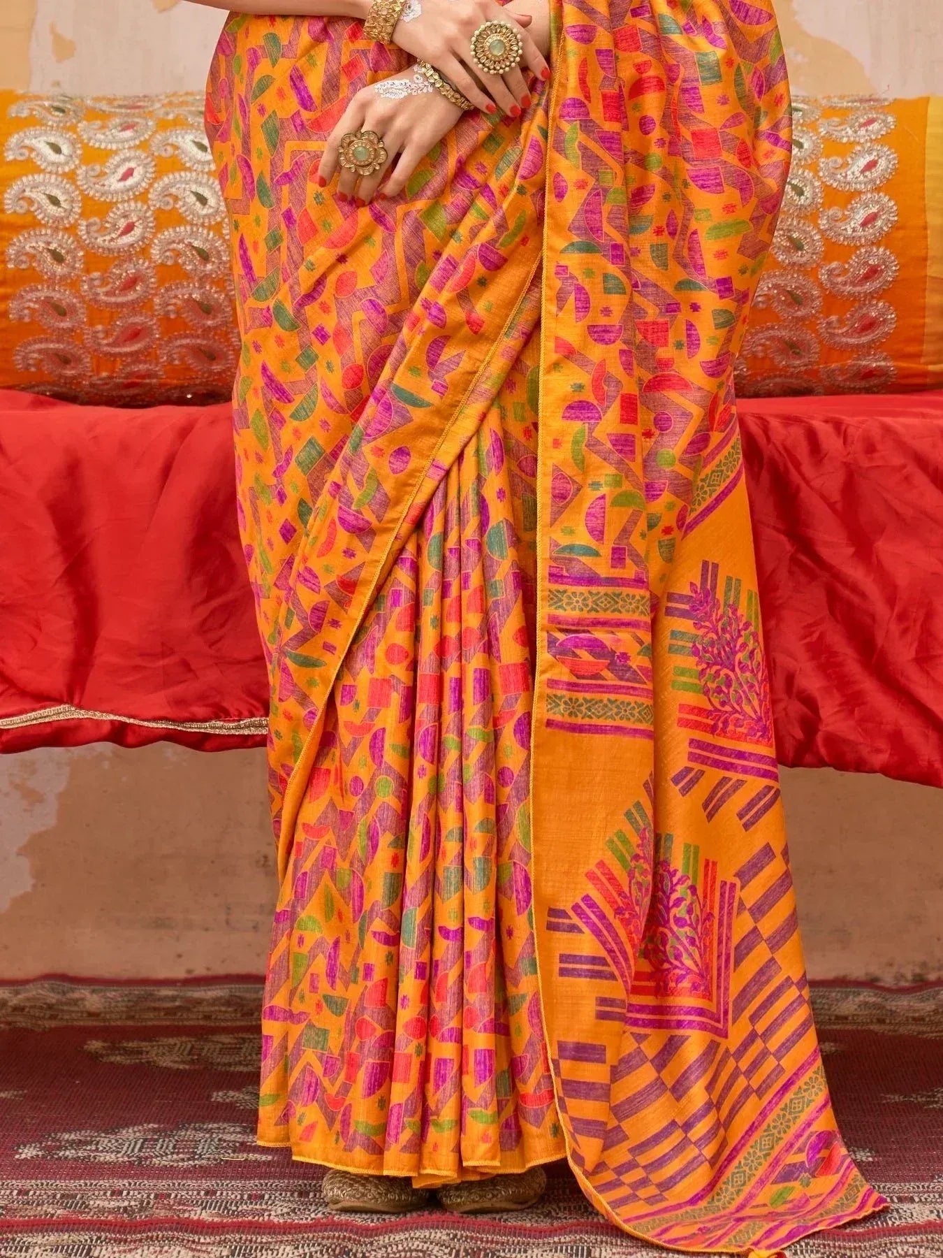 Vibrant orange saree with colorful geometric print, perfect for ethnic wear and festive occasions.
