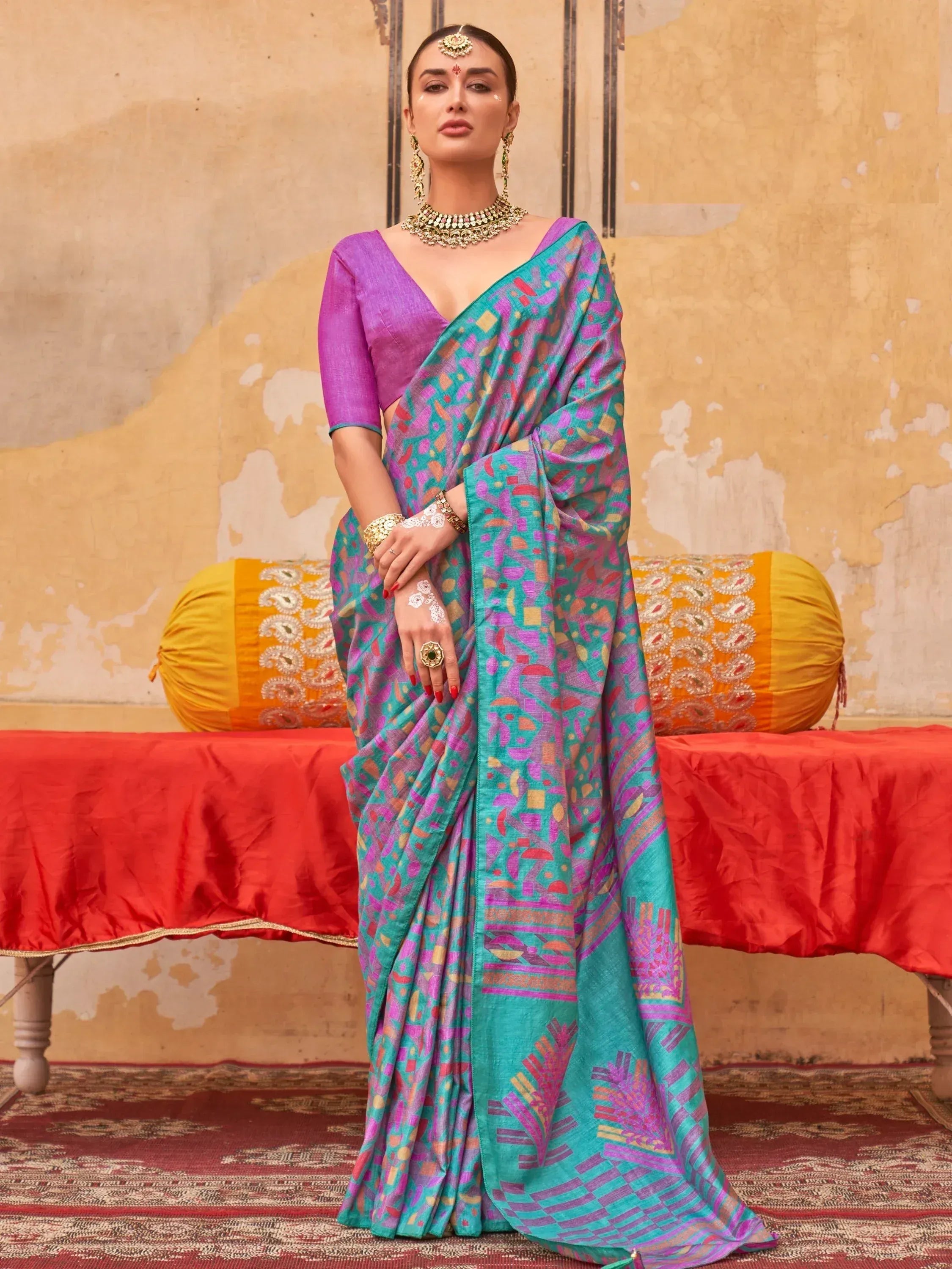 Woman in vibrant turquoise and purple printed saree with matching blouse, traditional Indian ethnic wear