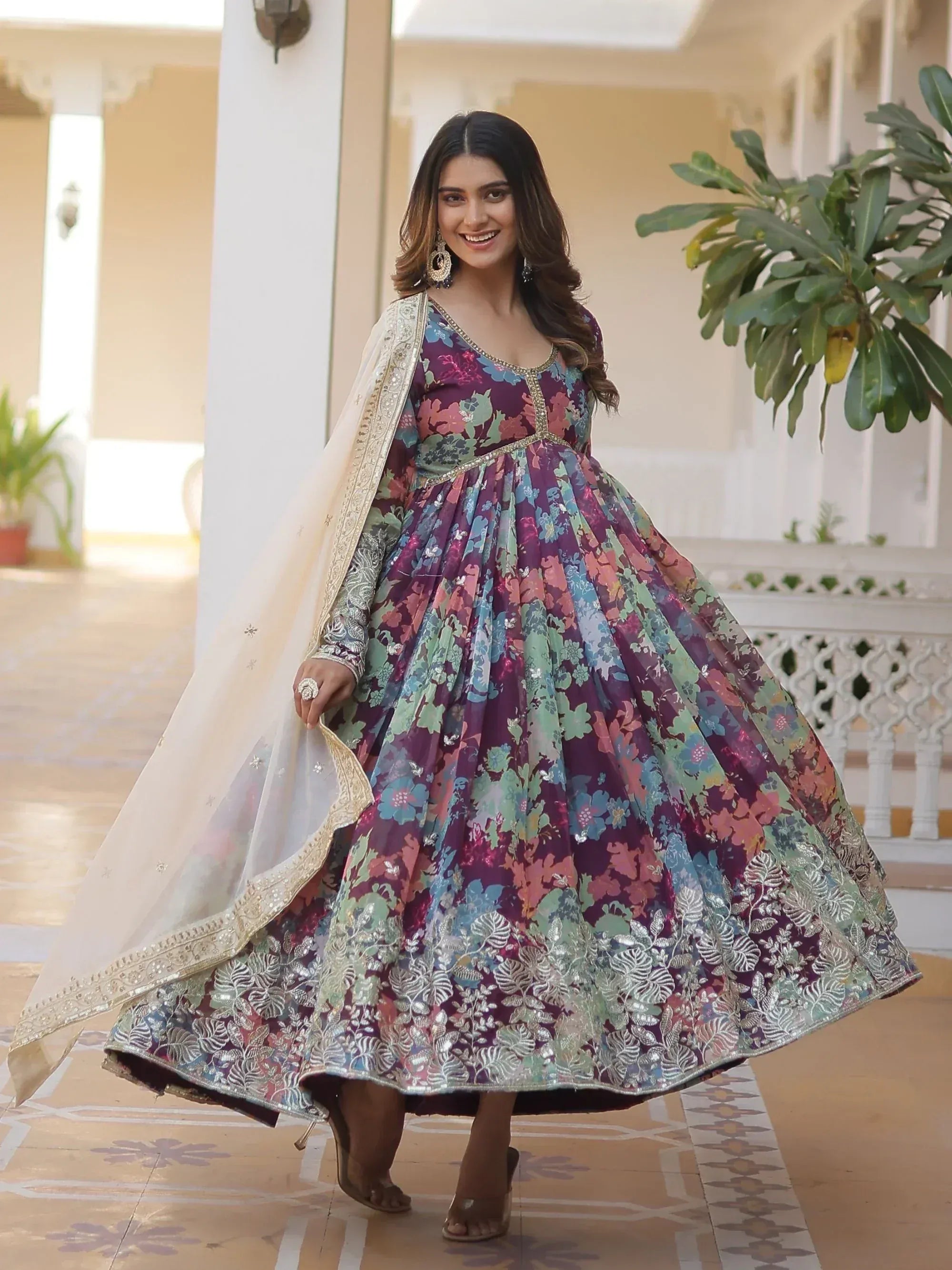 Woman in floral print Indian anarkali gown with gold embroidery and dupatta, perfect for festive occasions