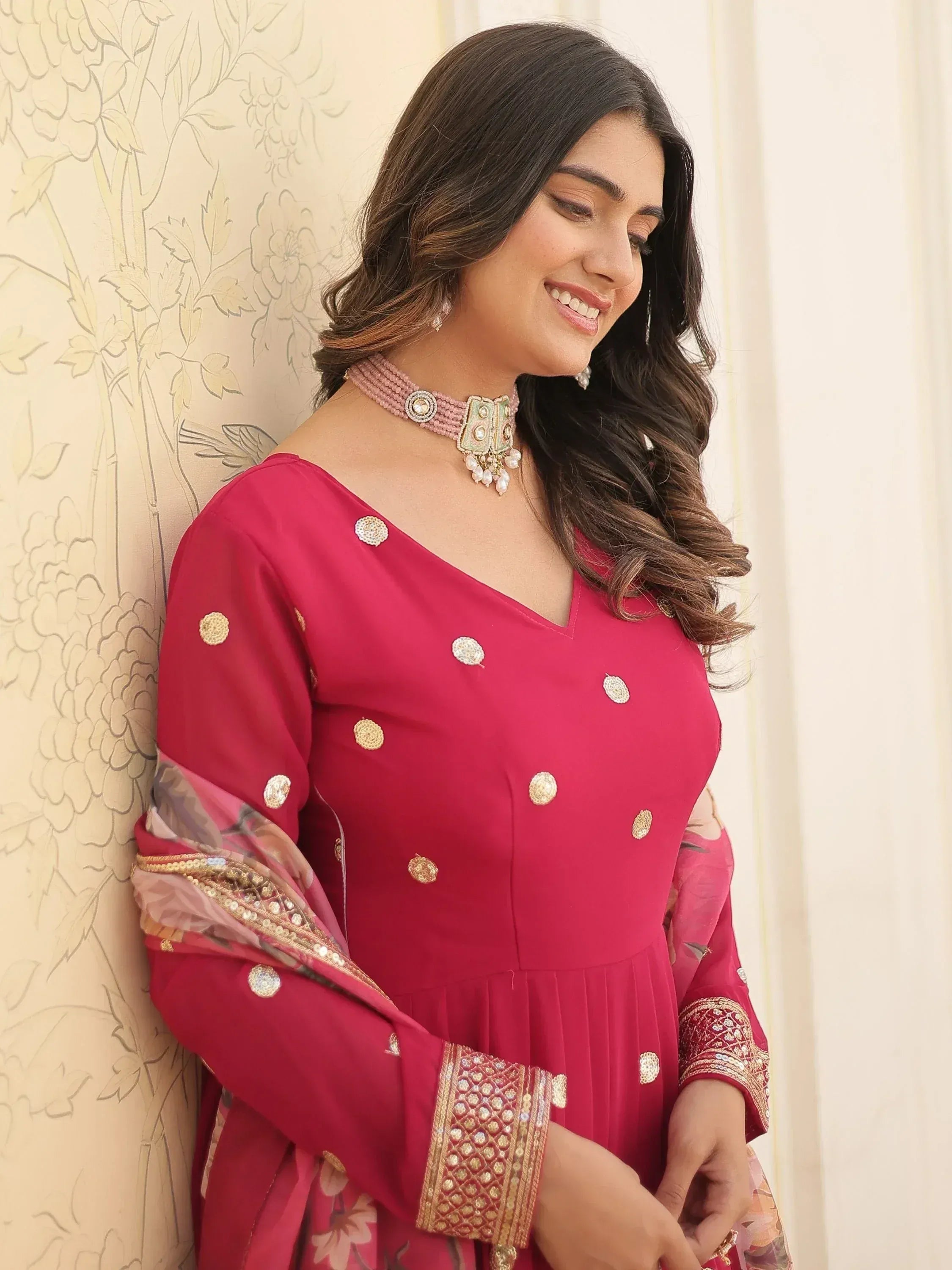 Woman in elegant pink ethnic gown with gold embroidery and floral dupatta, perfect for Indian occasions