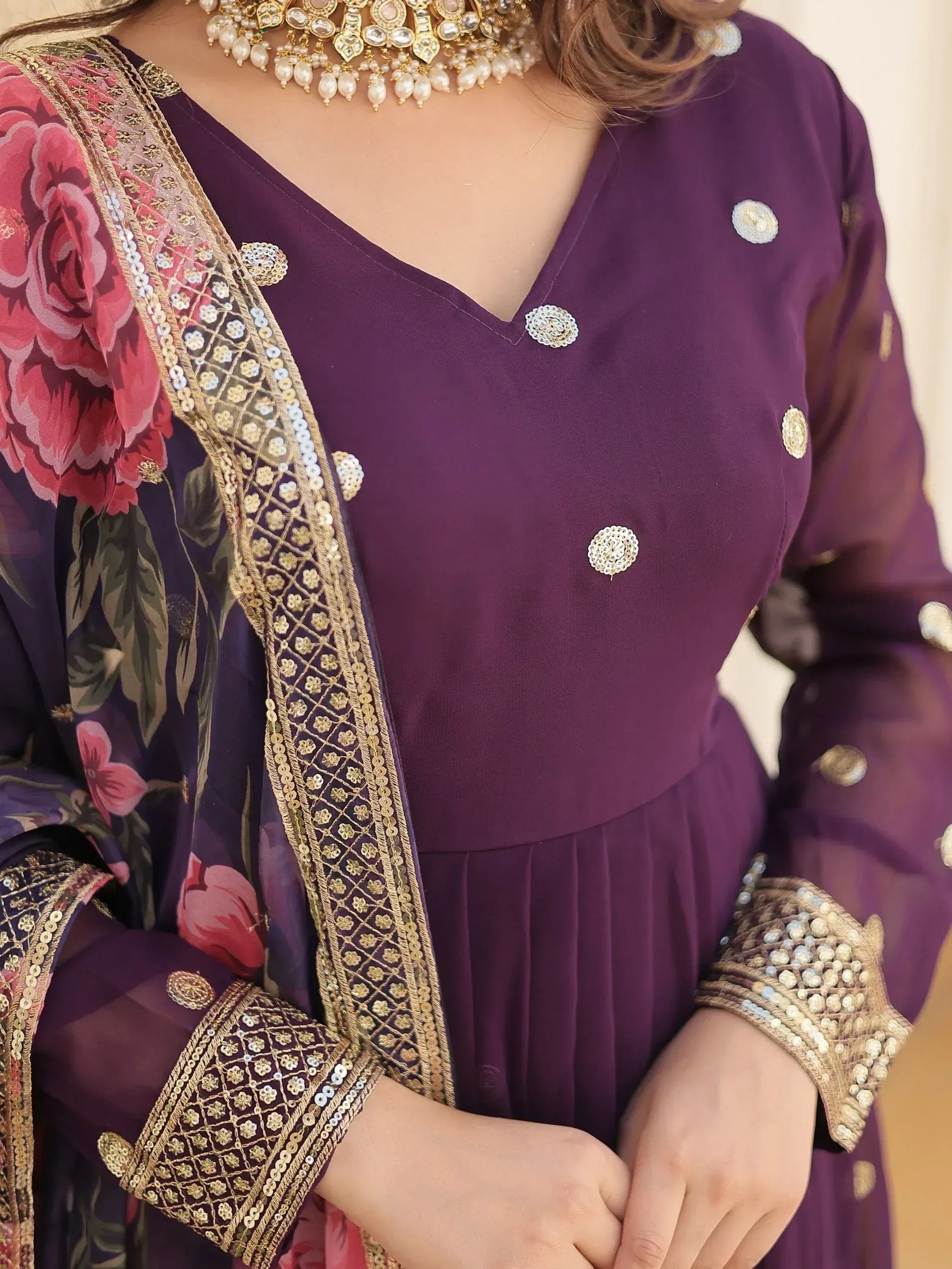 Purple ethnic gown with floral dupatta, gold embroidery, and pearl jewelry for Indian occasions