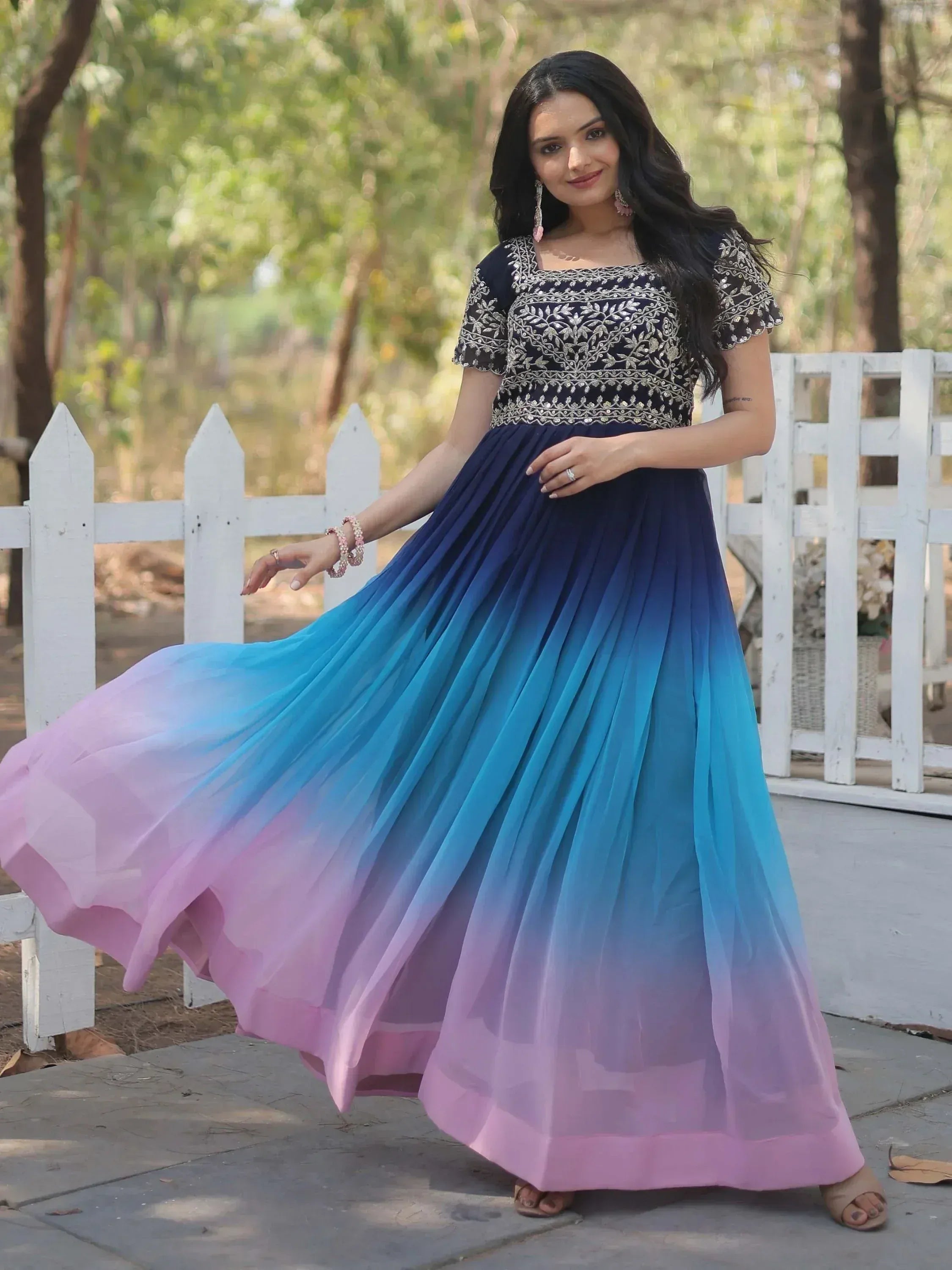 Woman in navy embroidered top with ombre blue to pink pleated skirt, Indian ethnic gown