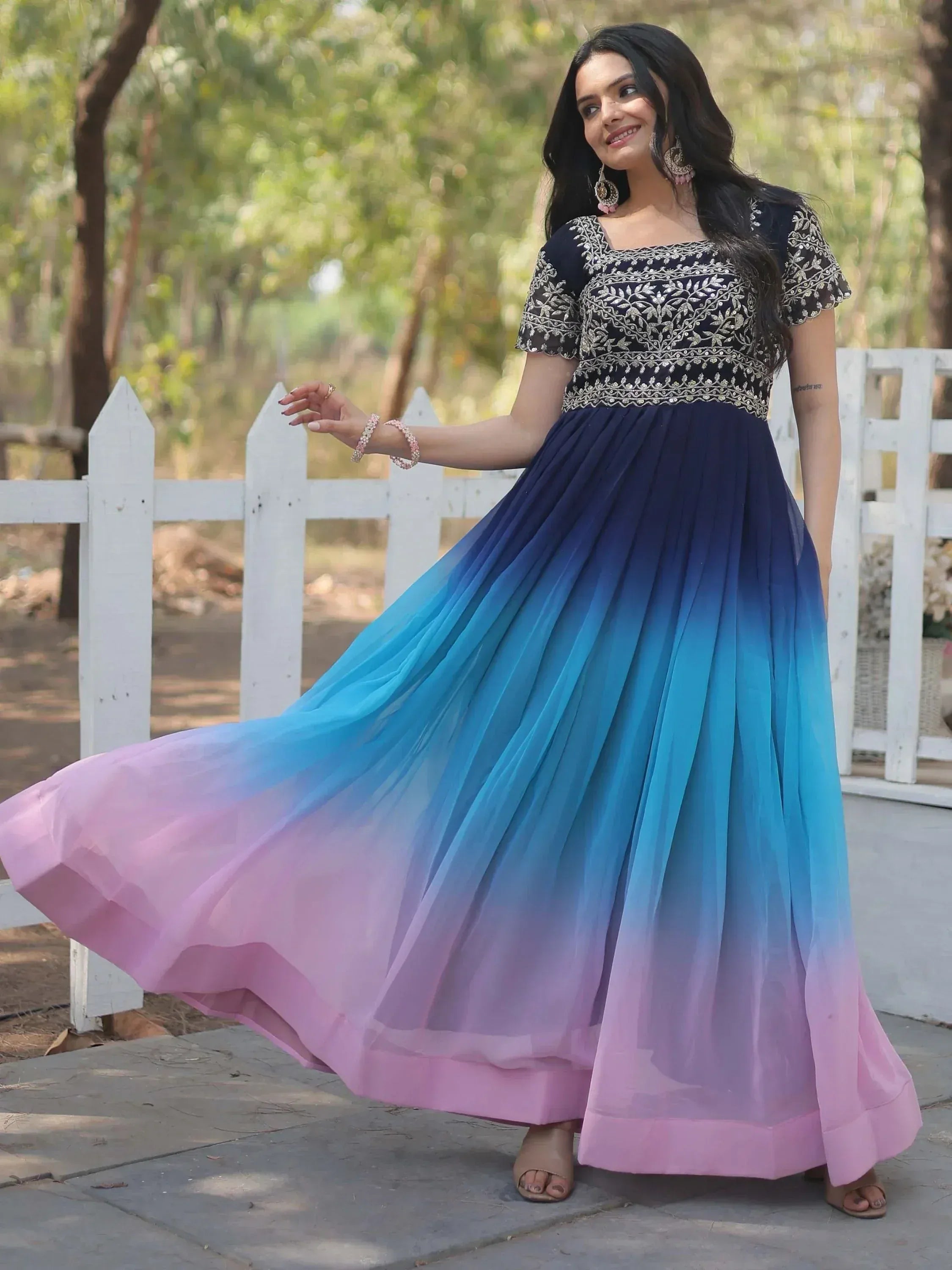 Woman in navy blue embroidered top with ombre blue to pink pleated skirt, ethnic gown for festive occasions