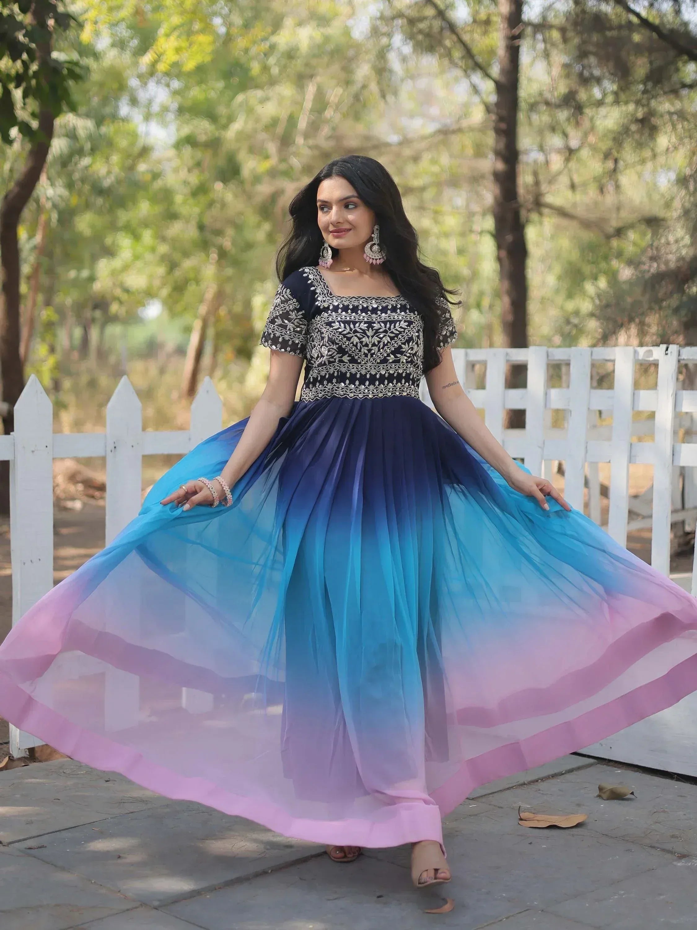 Woman in embroidered navy blue and ombre pink-blue ethnic gown, perfect for Indian festive occasions.