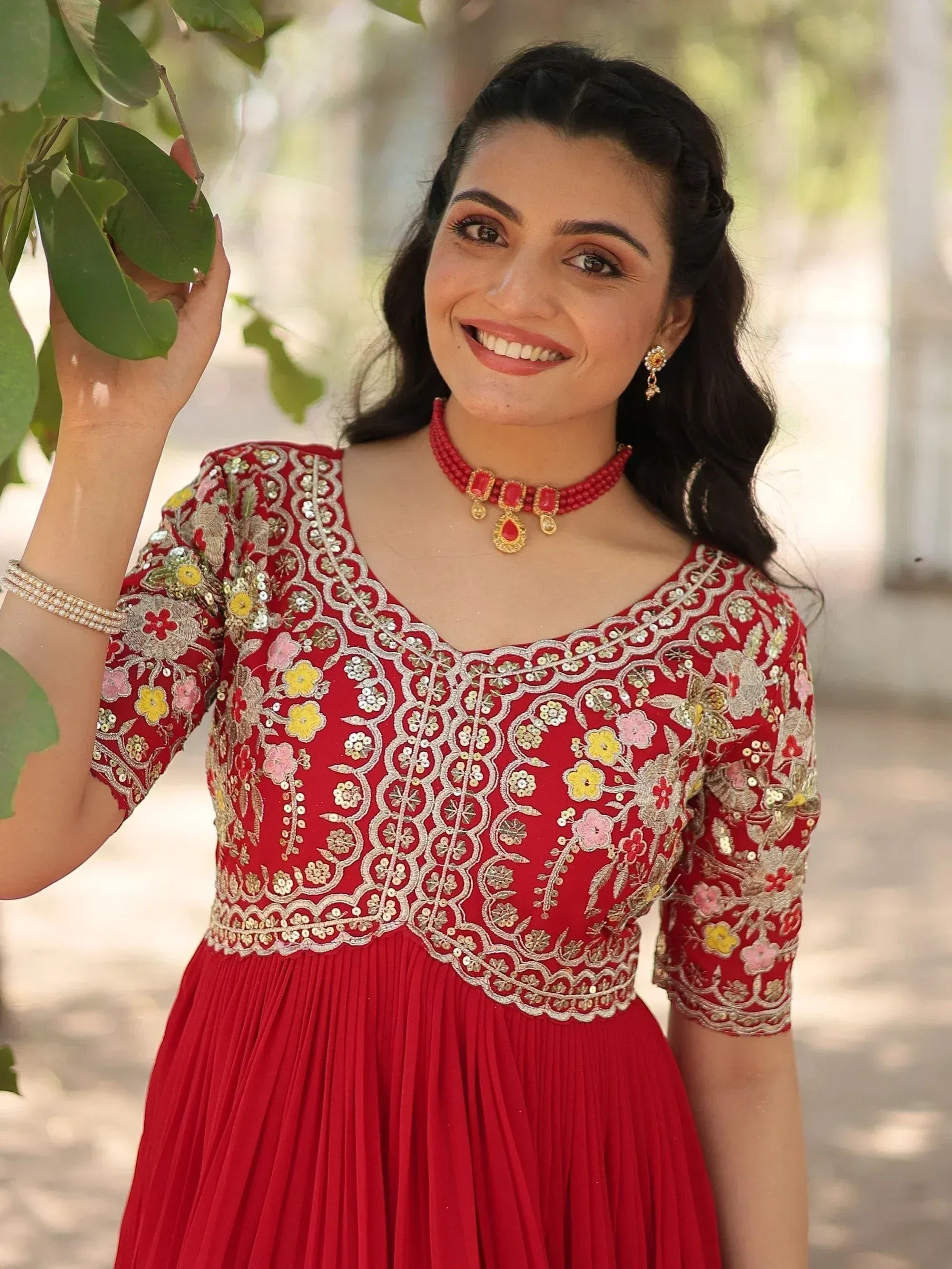 Red embroidered ethnic gown with floral detailing, perfect for Indian celebrations and festive occasions.