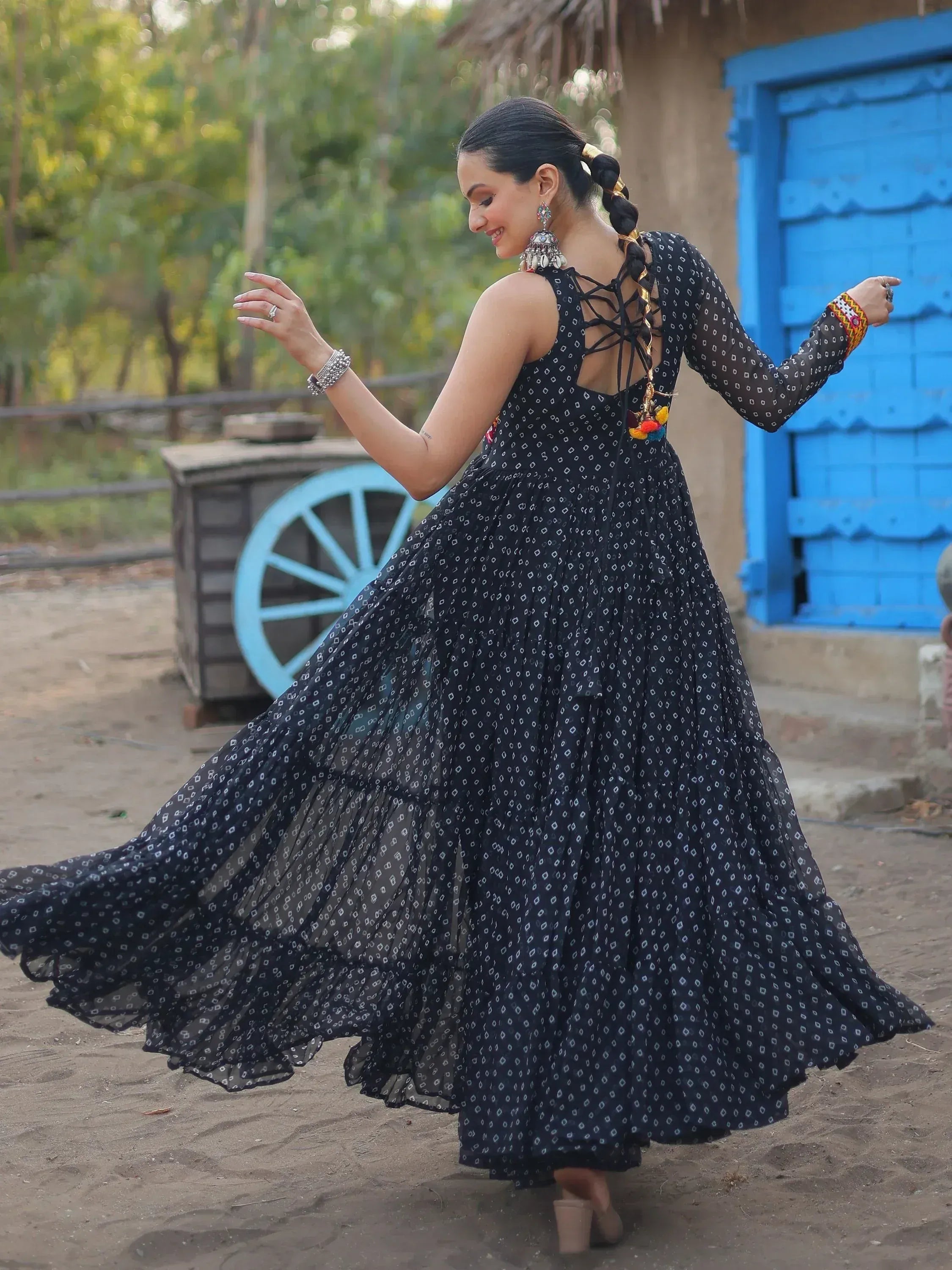 Woman twirling in black printed ethnic gown with lace-up back, perfect for Indian festive occasions