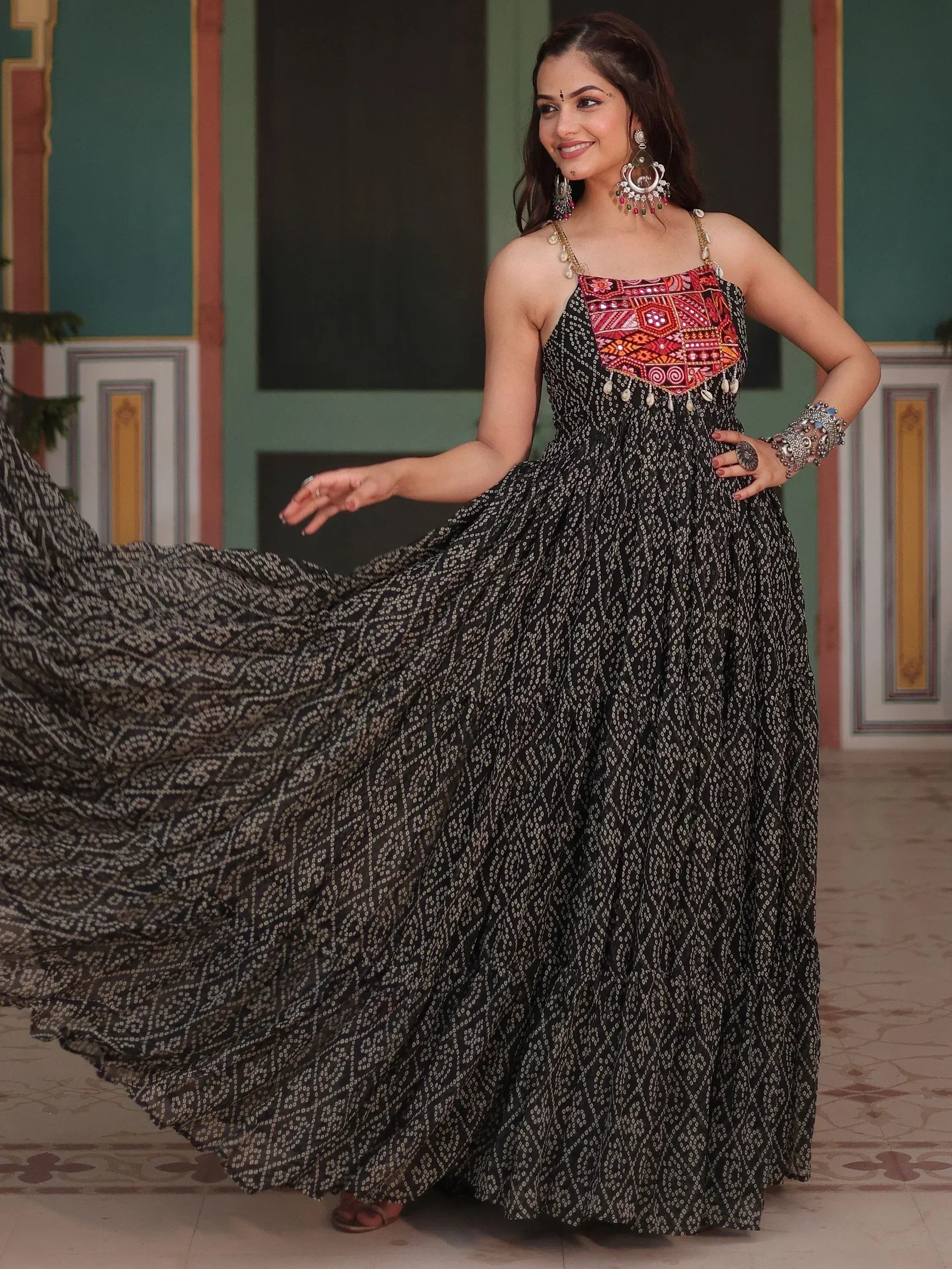 Woman in black and white printed ethnic gown with red embroidered bodice, perfect for Indian festive occasions.