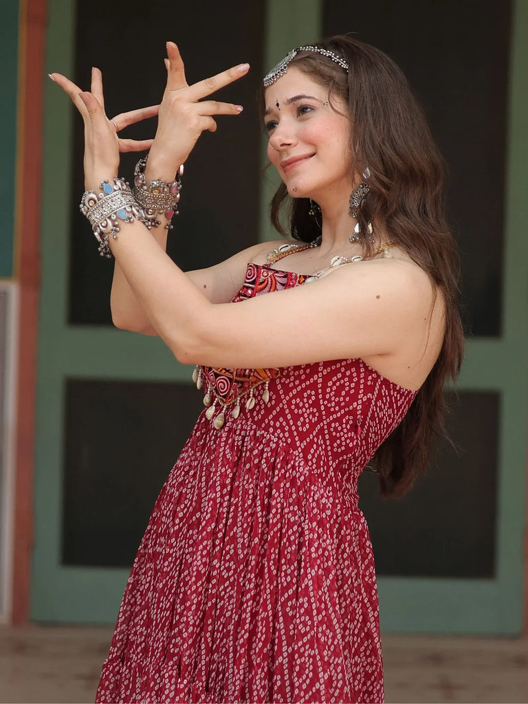 Woman in red ethnic gown with intricate jewelry, showcasing traditional Indian dance pose