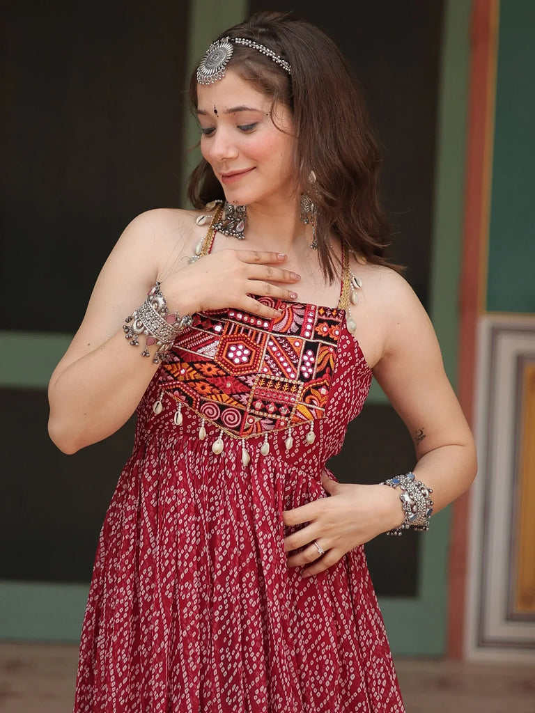Woman in red ethnic gown with mirror work, traditional jewelry, and headpiece for Indian festive wear