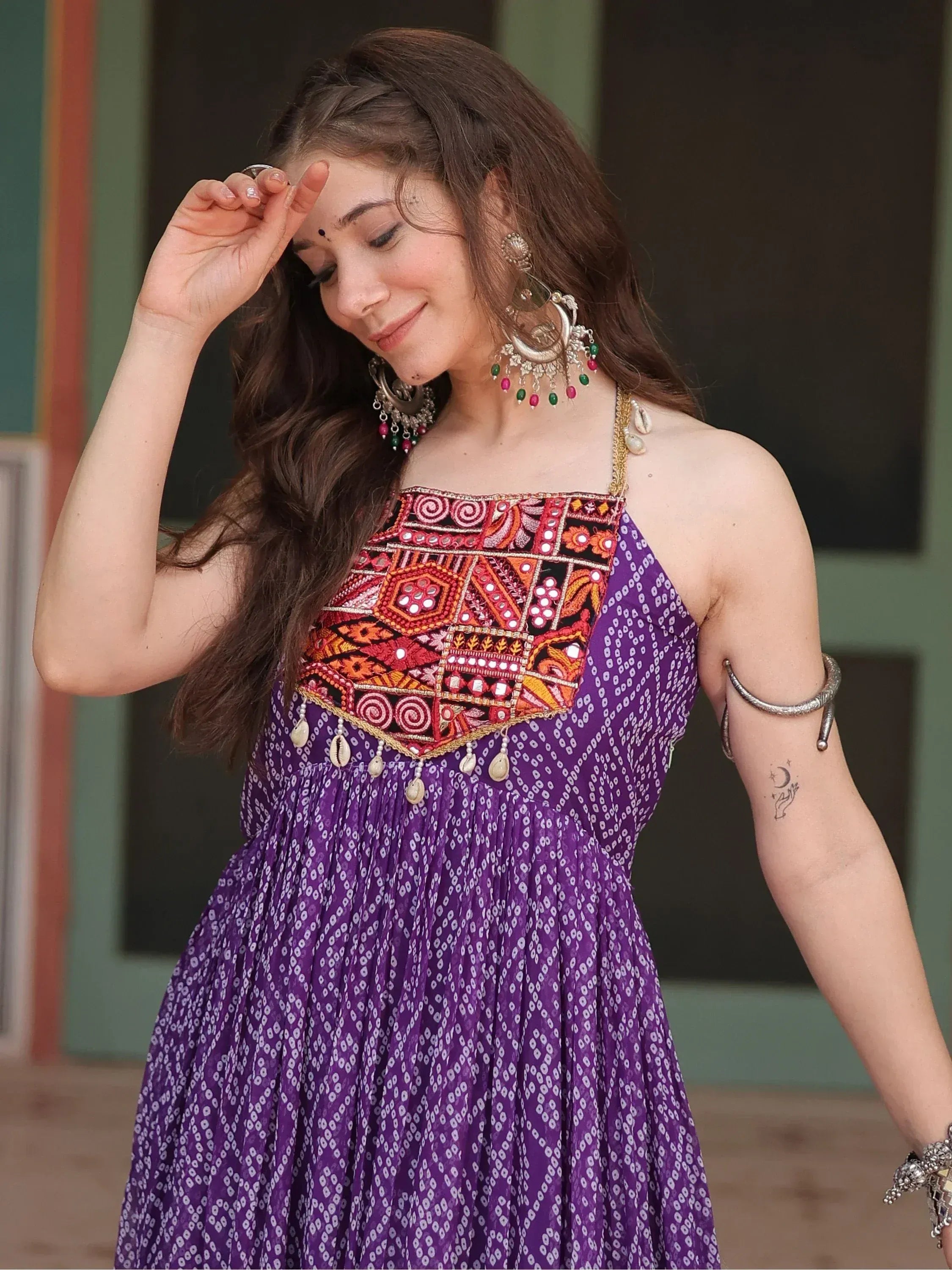 Purple ethnic gown with mirror work and embroidery, paired with statement jewelry for Indian wear