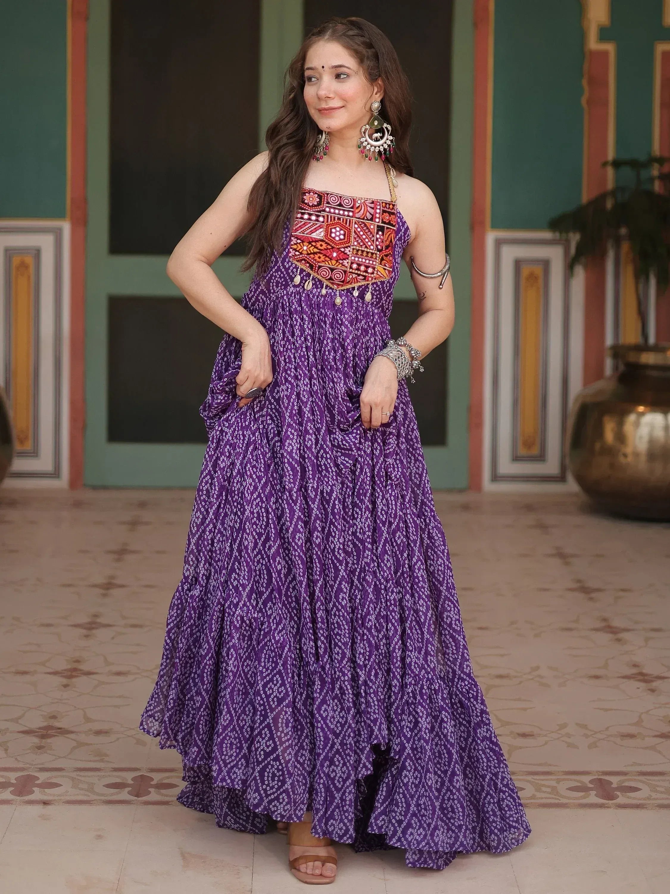 Purple ethnic gown with embroidered bodice and printed skirt, styled with traditional jewelry for Indian wear.