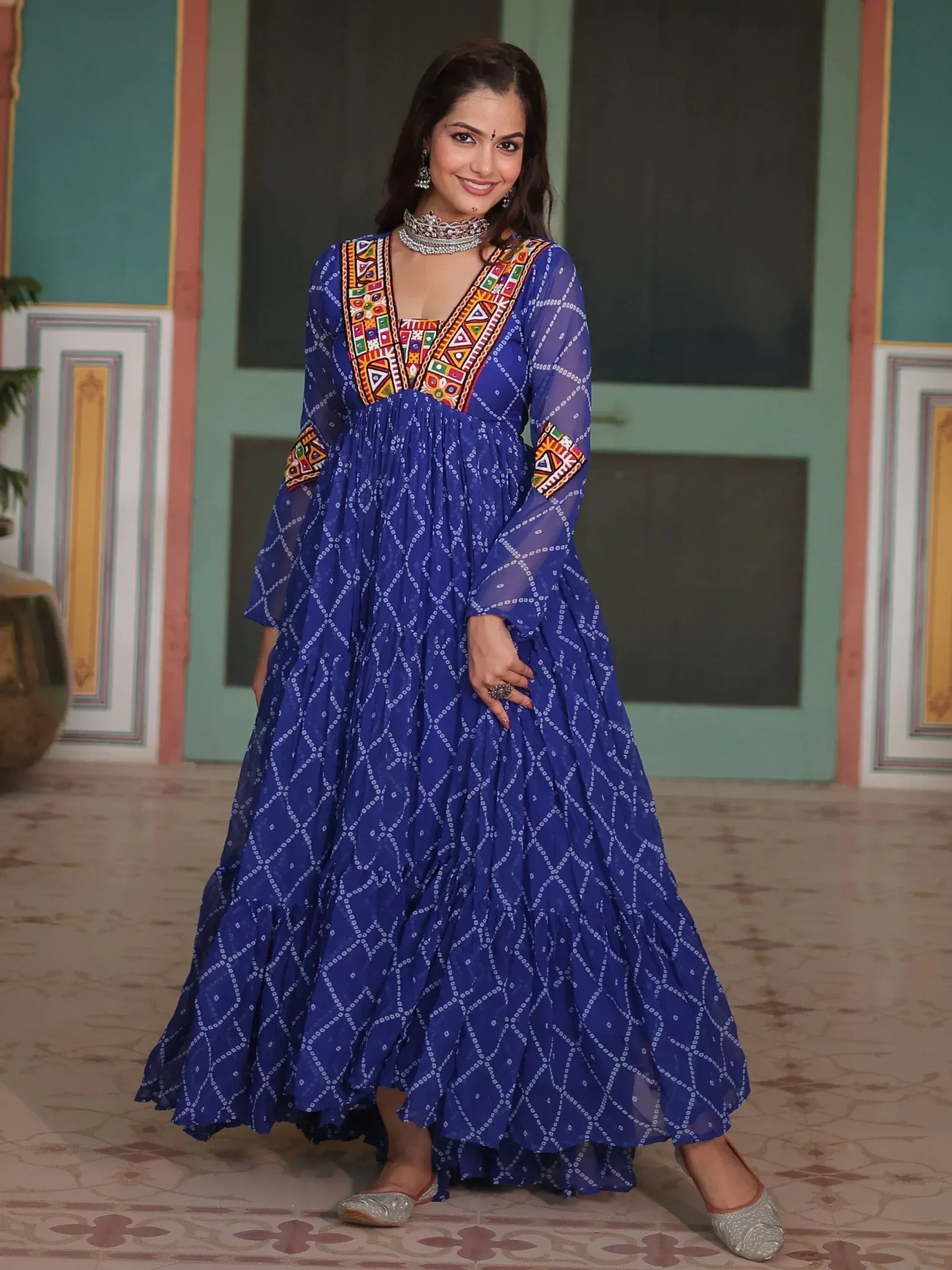 Blue ethnic gown with colorful embroidery and sheer sleeves, perfect for Indian festive occasions.