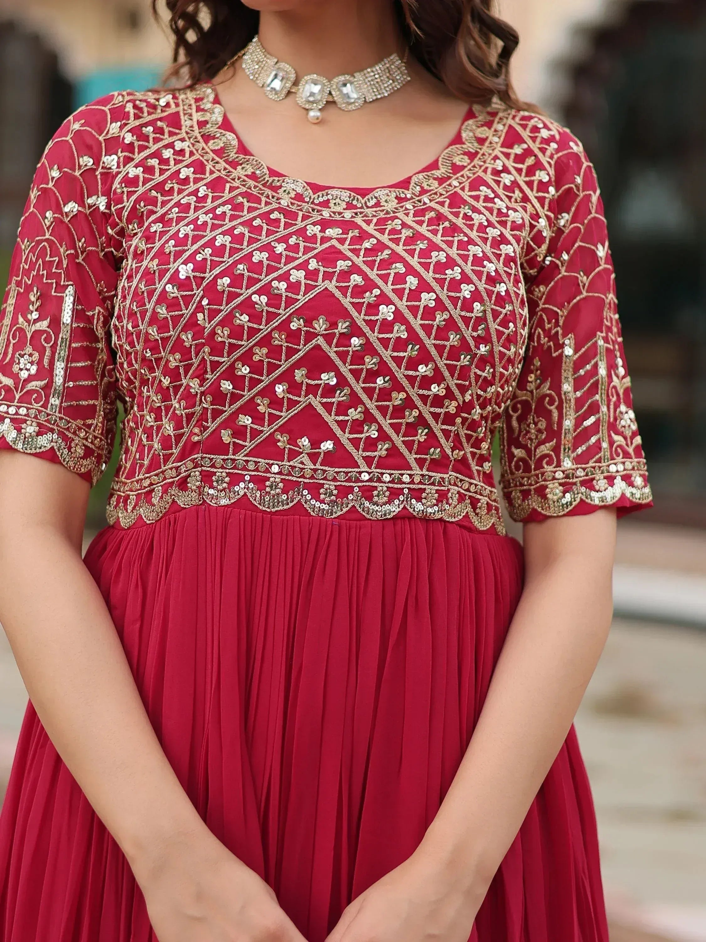 Red ethnic gown with gold embroidery and sequins, paired with statement necklace