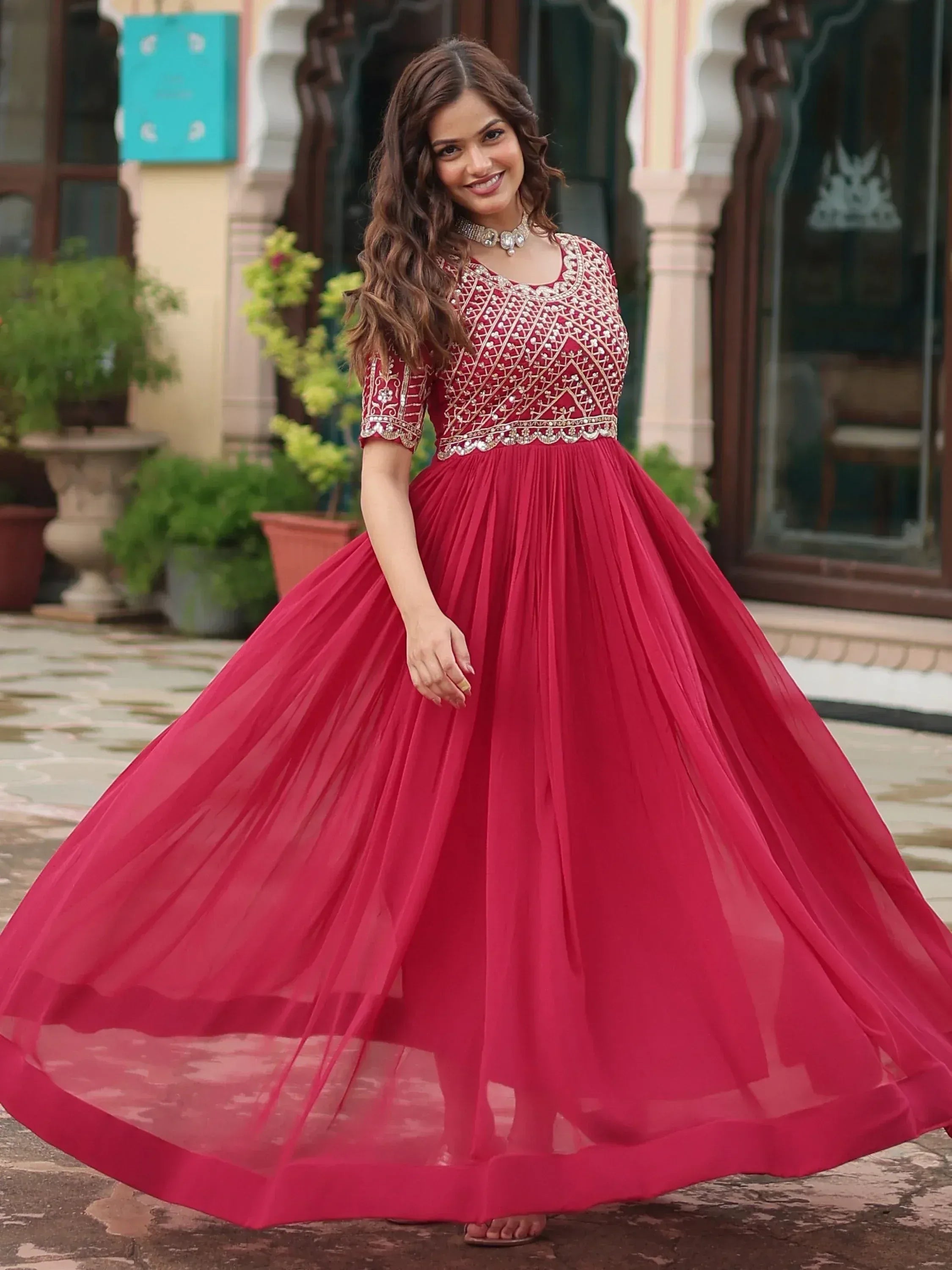 Woman in maroon embroidered ethnic gown with flared tulle skirt, perfect for Indian weddings and parties