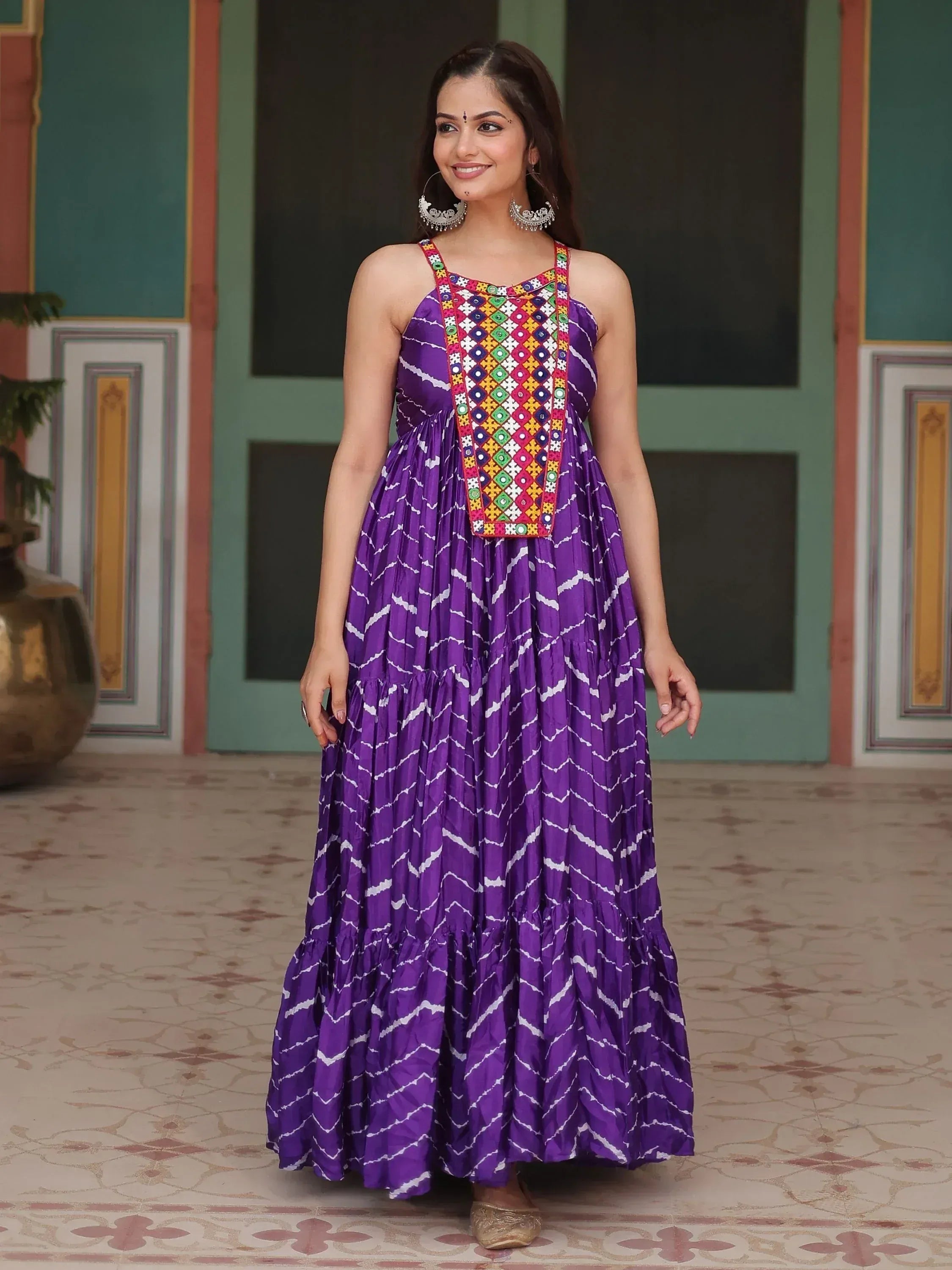 Purple ethnic gown with colorful mirror work and white zigzag print, perfect for festive occasions.
