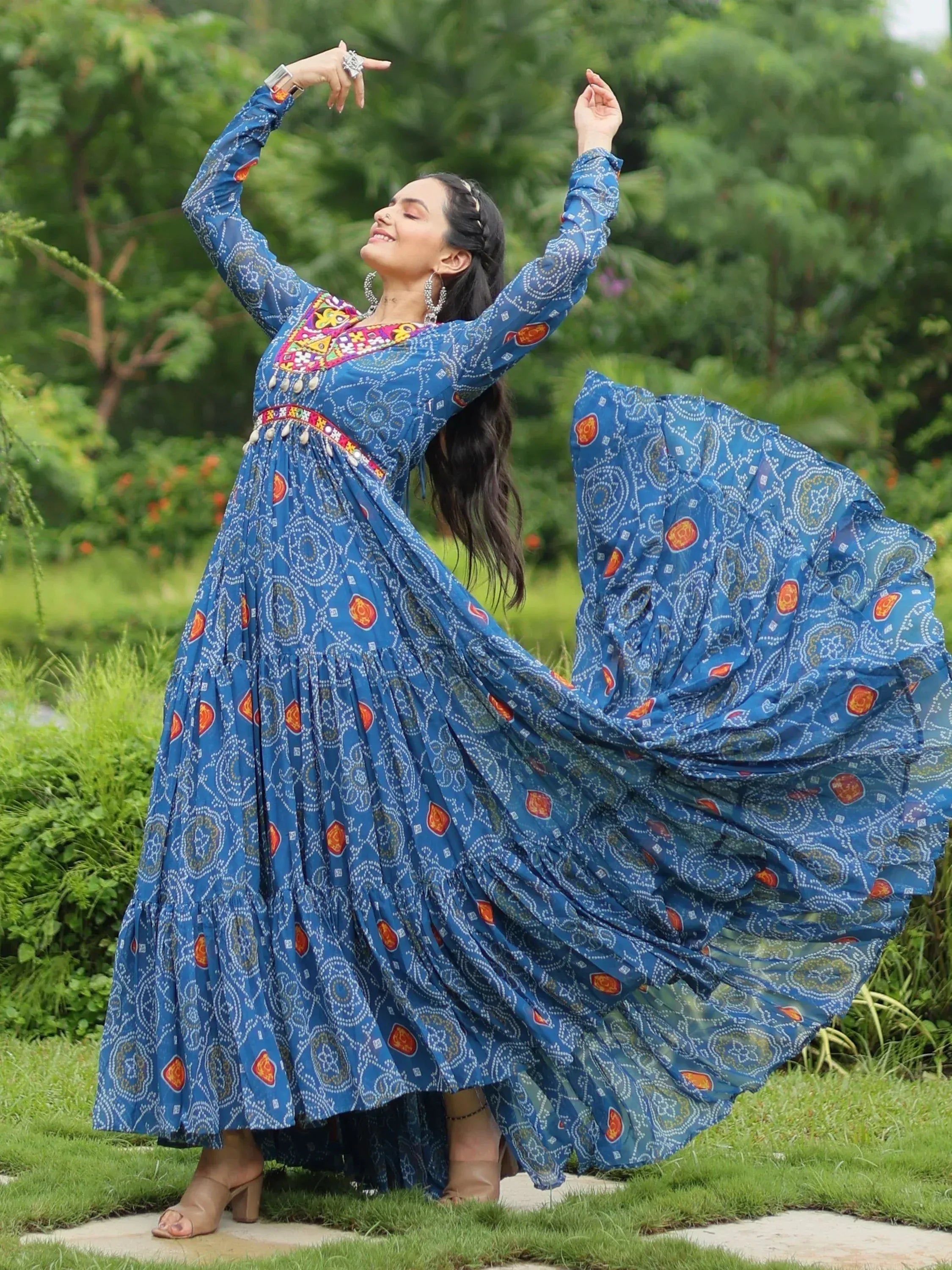 Woman twirling in blue printed ethnic gown with embroidery, perfect for festive occasions and Indian wear.