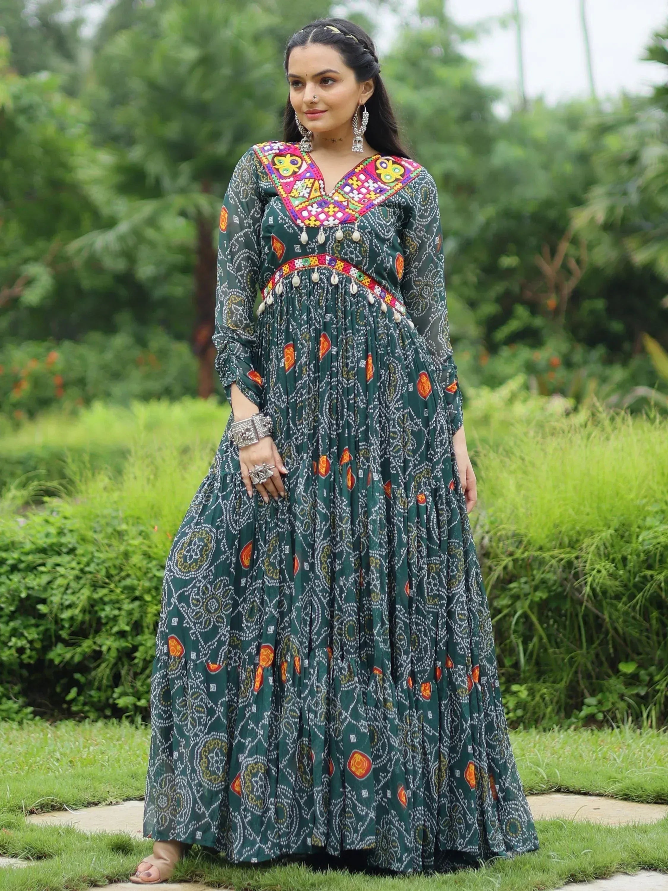 Woman in green printed ethnic gown with colorful embroidery and mirror work, perfect for Indian festive occasions.