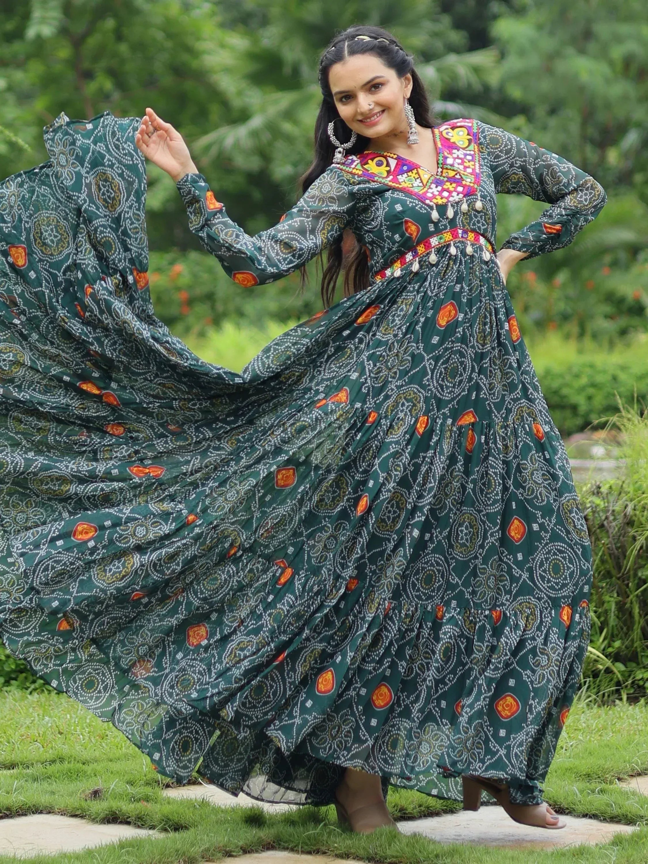 Woman in green printed ethnic gown with colorful embroidery, twirling outdoors