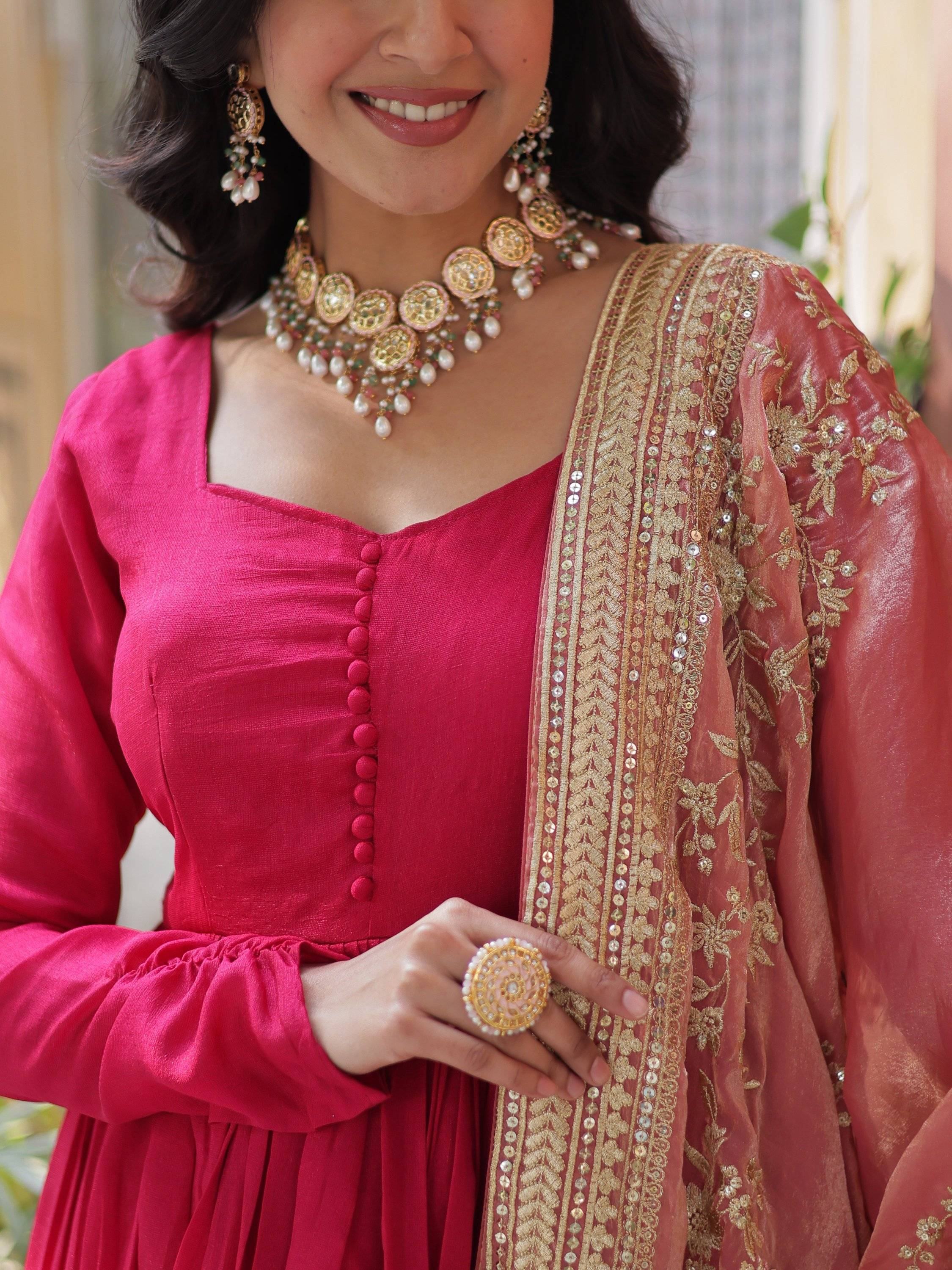 Woman in pink ethnic dress with gold embroidered dupatta and statement jewelry