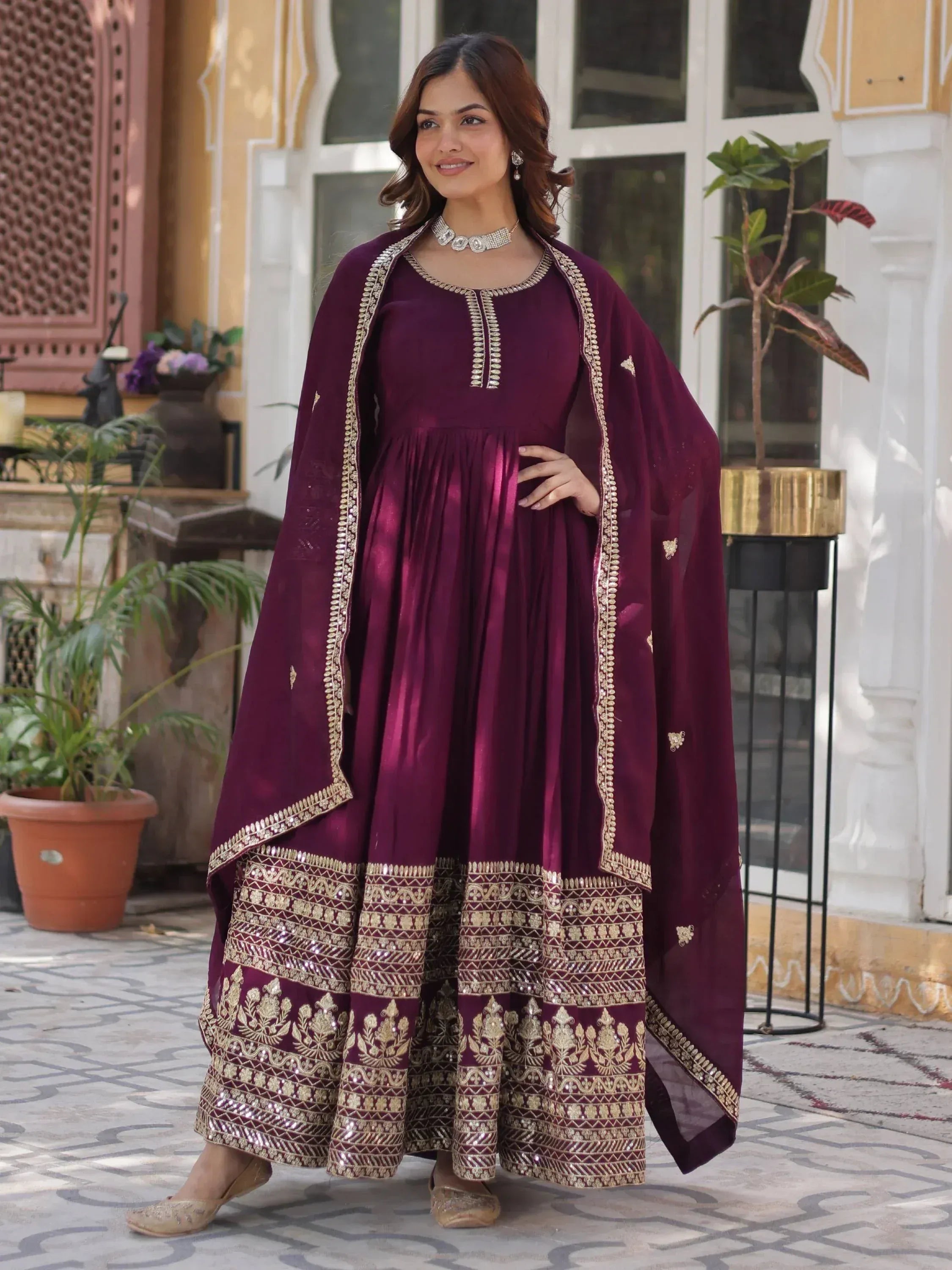 Elegant maroon ethnic gown with gold embroidery and matching dupatta for festive occasions