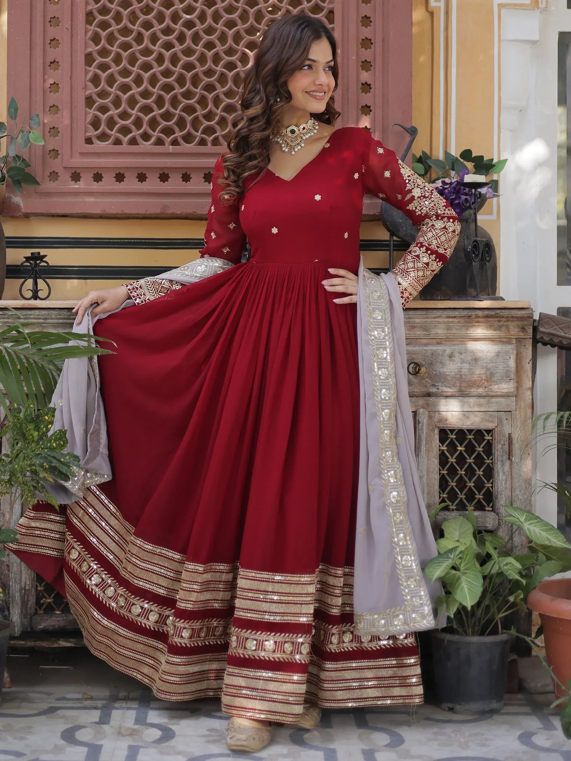 Woman wearing maroon Anarkali gown with gold embroidery and dupatta, Indian ethnic wear