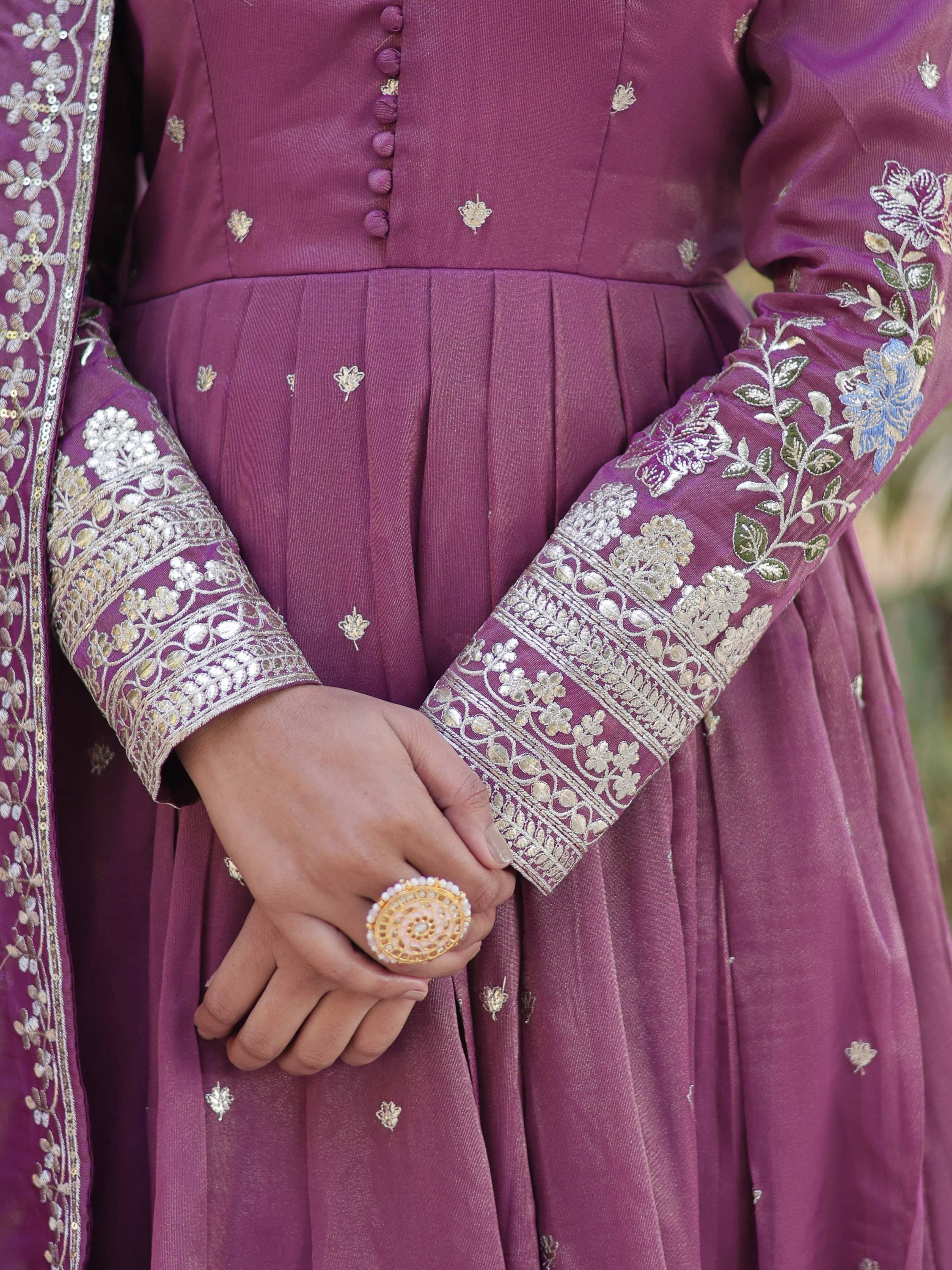 Purple Indian ethnic gown with gold floral embroidery and pleated skirt, paired with ornate ring