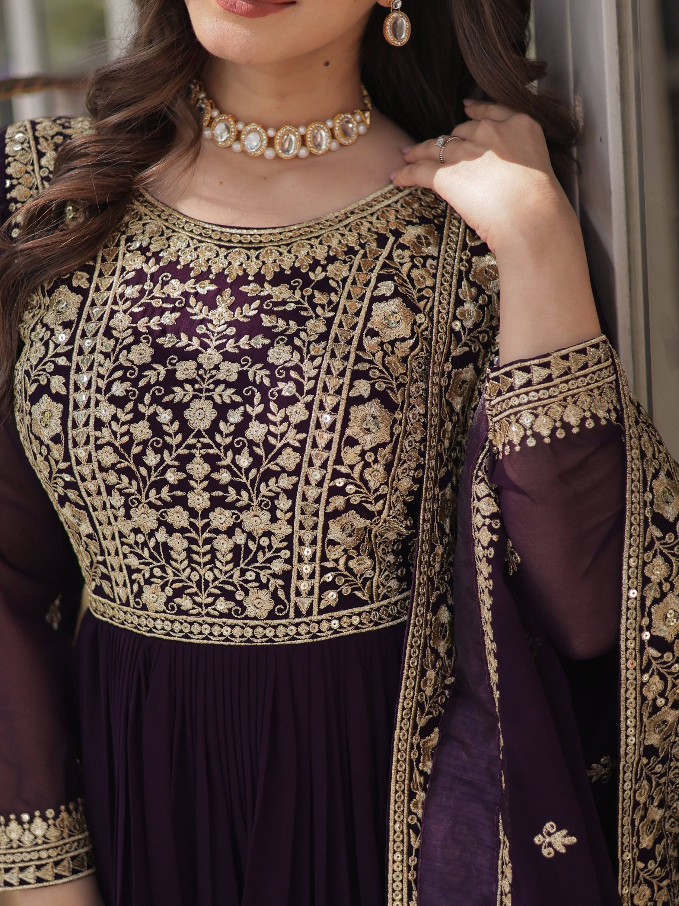 Woman in wine color ethnic gown with gold floral embroidery and sheer sleeves