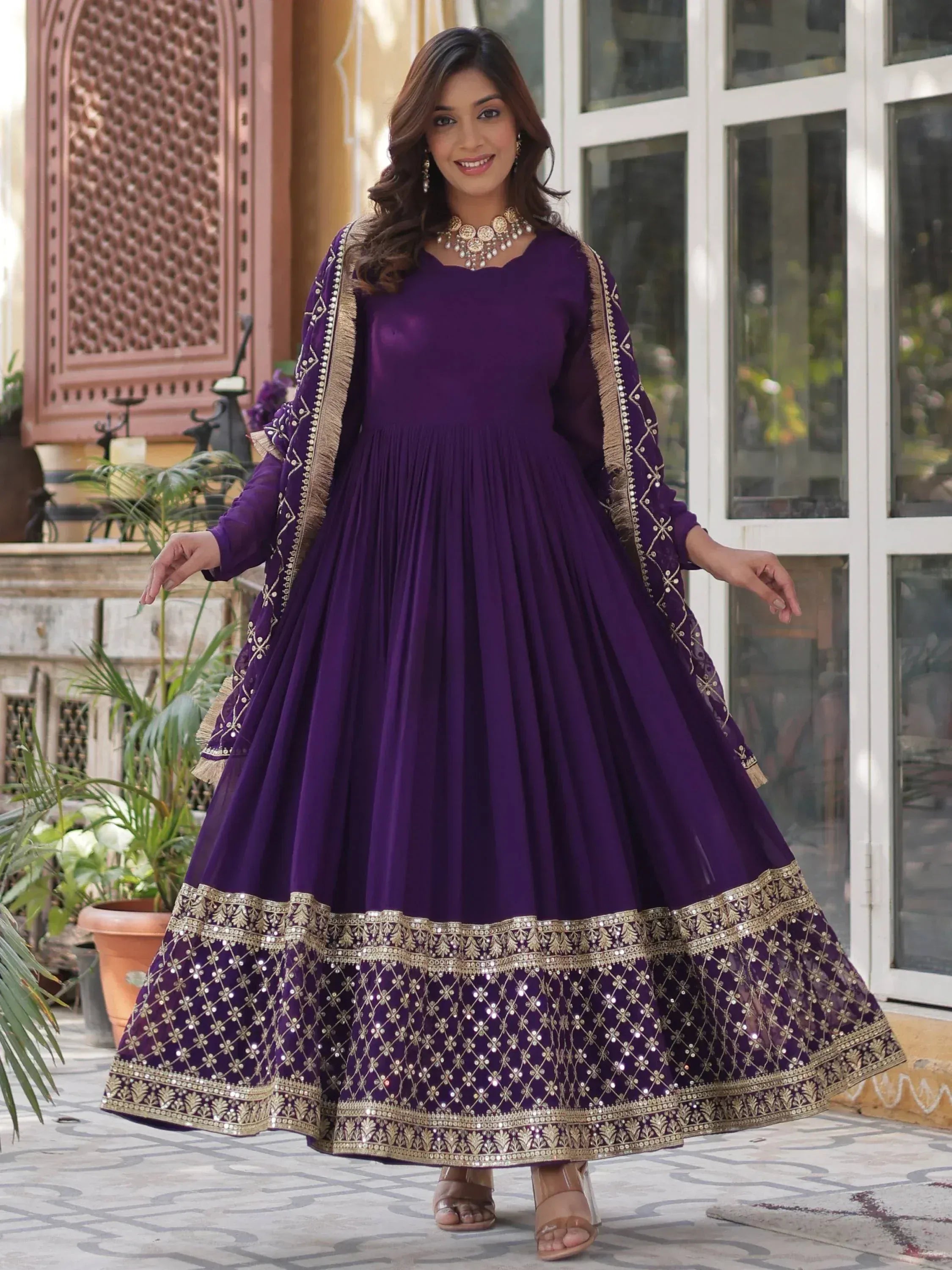 Purple ethnic gown with gold embroidery and mirror work, perfect for Indian occasions