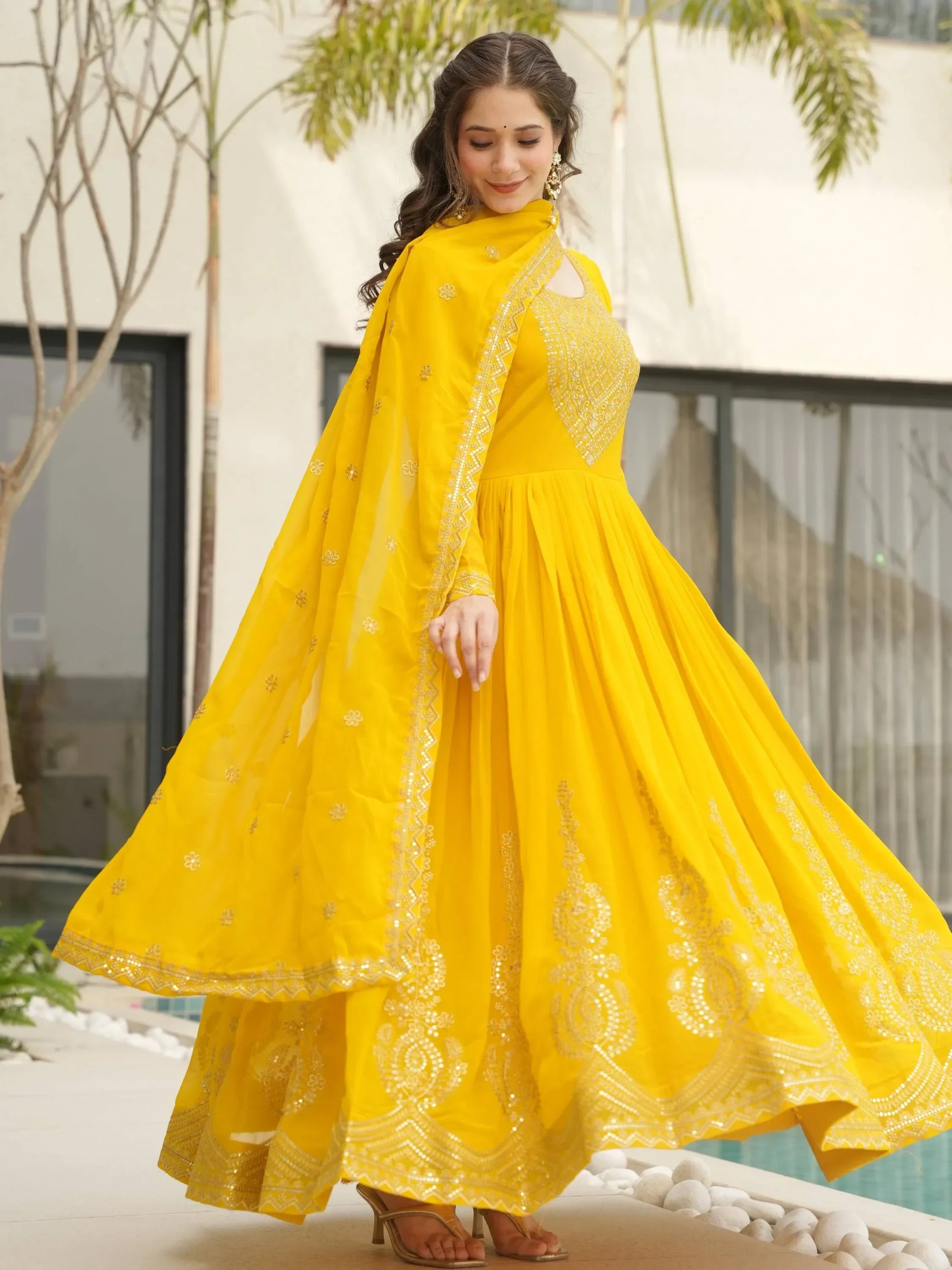 Woman in yellow embroidered Anarkali gown with dupatta, outdoor ethnic fashion
