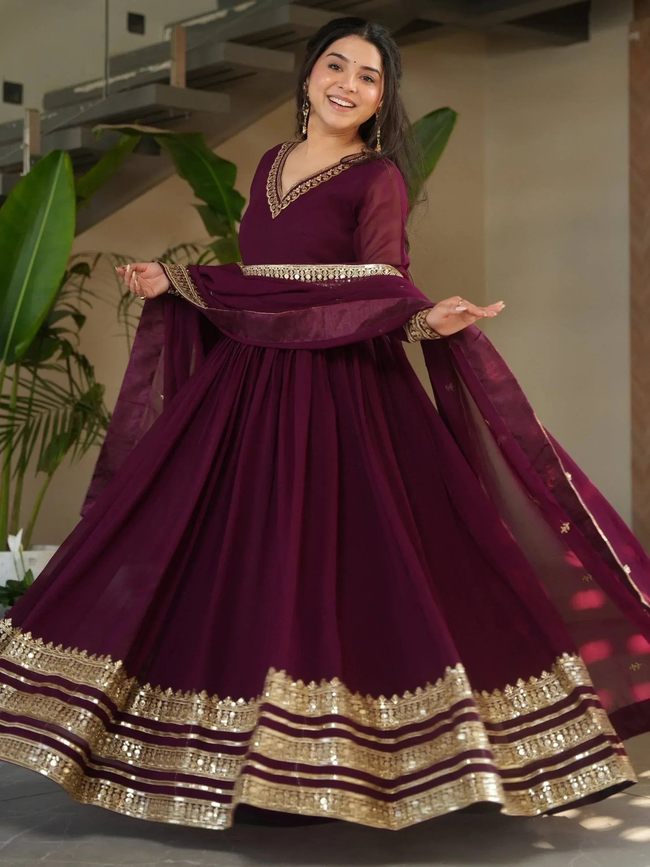 Elegant maroon ethnic gown with gold embroidery, perfect for Indian weddings and festive occasions.