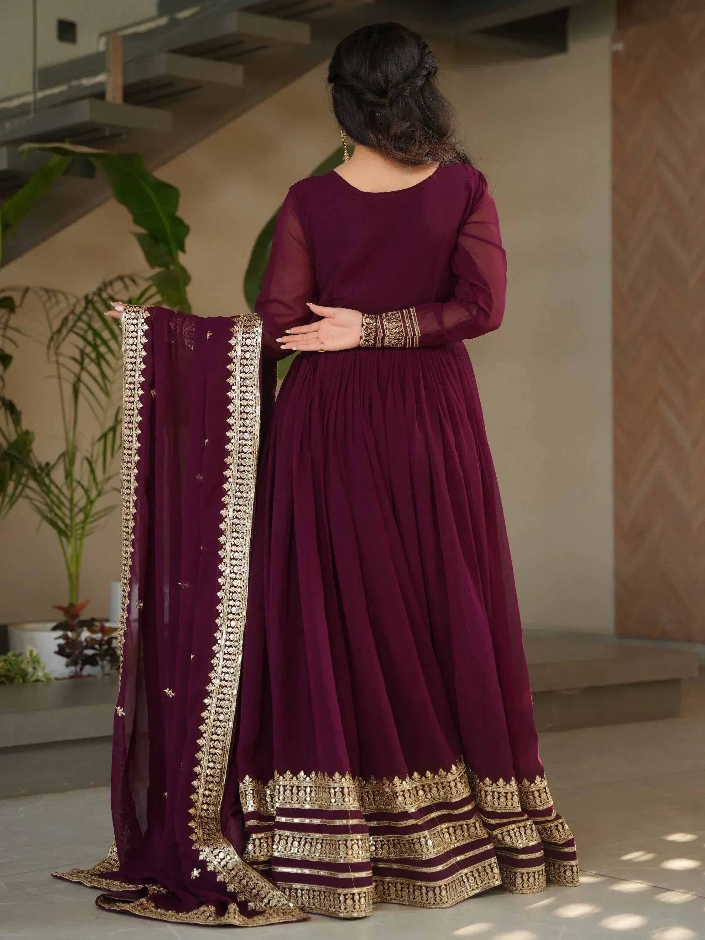 Elegant maroon ethnic gown with gold embroidery, perfect for Indian weddings and festive occasions.